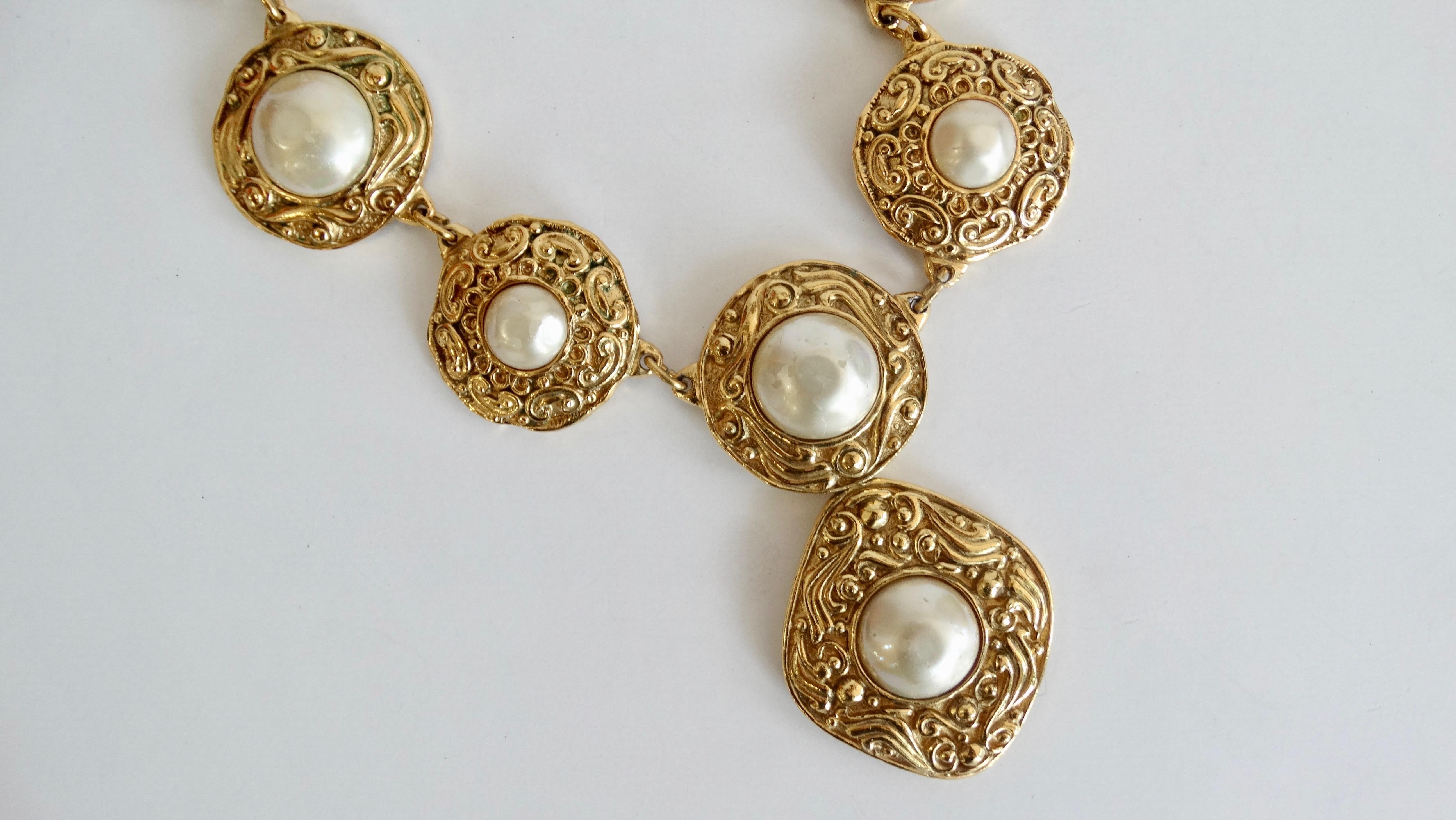 Complete your collection with this vintage Chanel statement piece! Circa early 1980s, this necklace features ornate linked  pendants featuring a faux pearl inside a decoratively carved gold plated round setting. Includes a diamond shaped drop