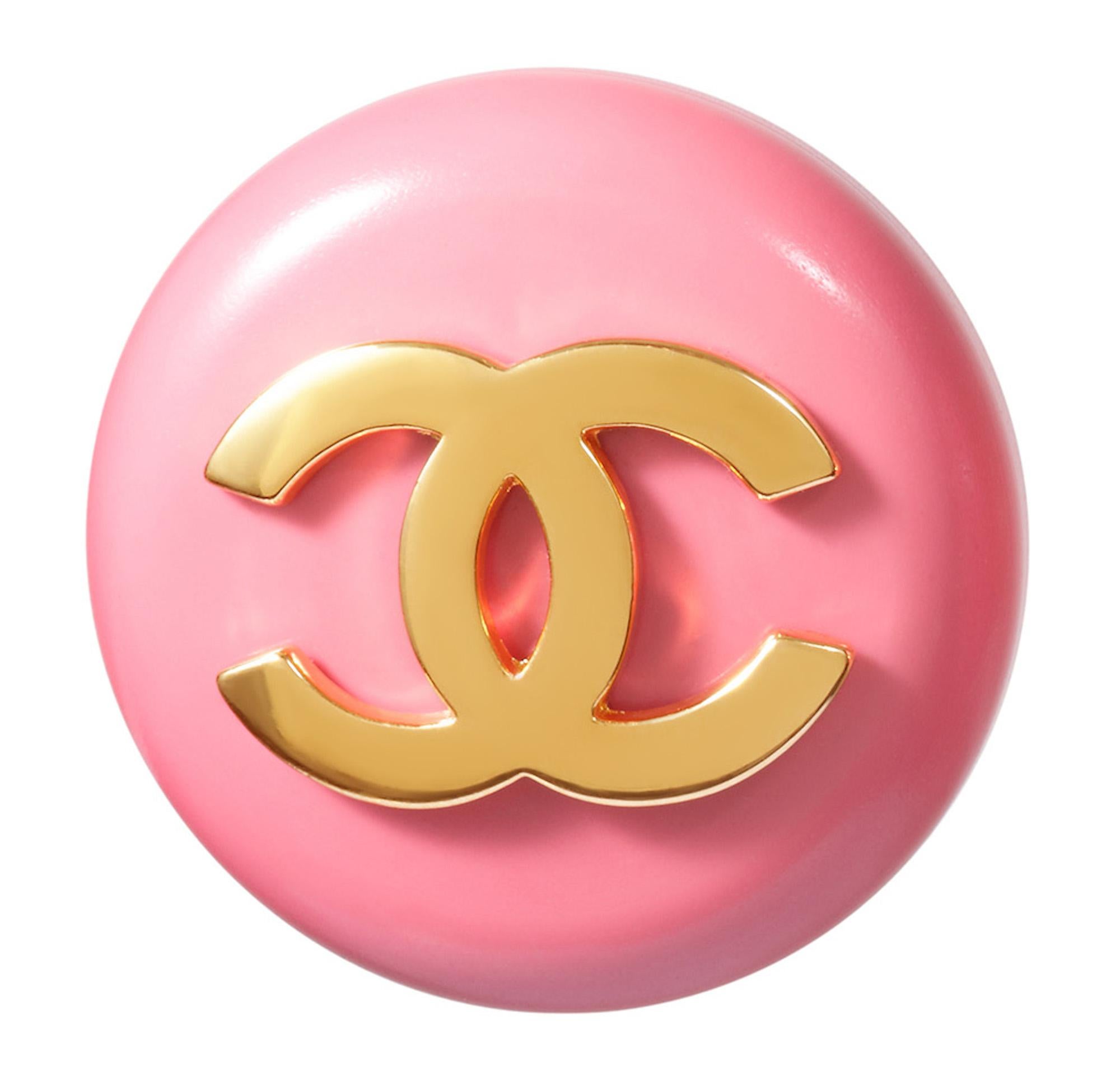 These fantastic 1980s Chanel pink lucite earrings feature a bold gold tone CC motif. Each piece measures 1.4 in diameter and is made of rose pink lucite mounted on a gold-plated backing. The designers signature is located below the clip fastenings