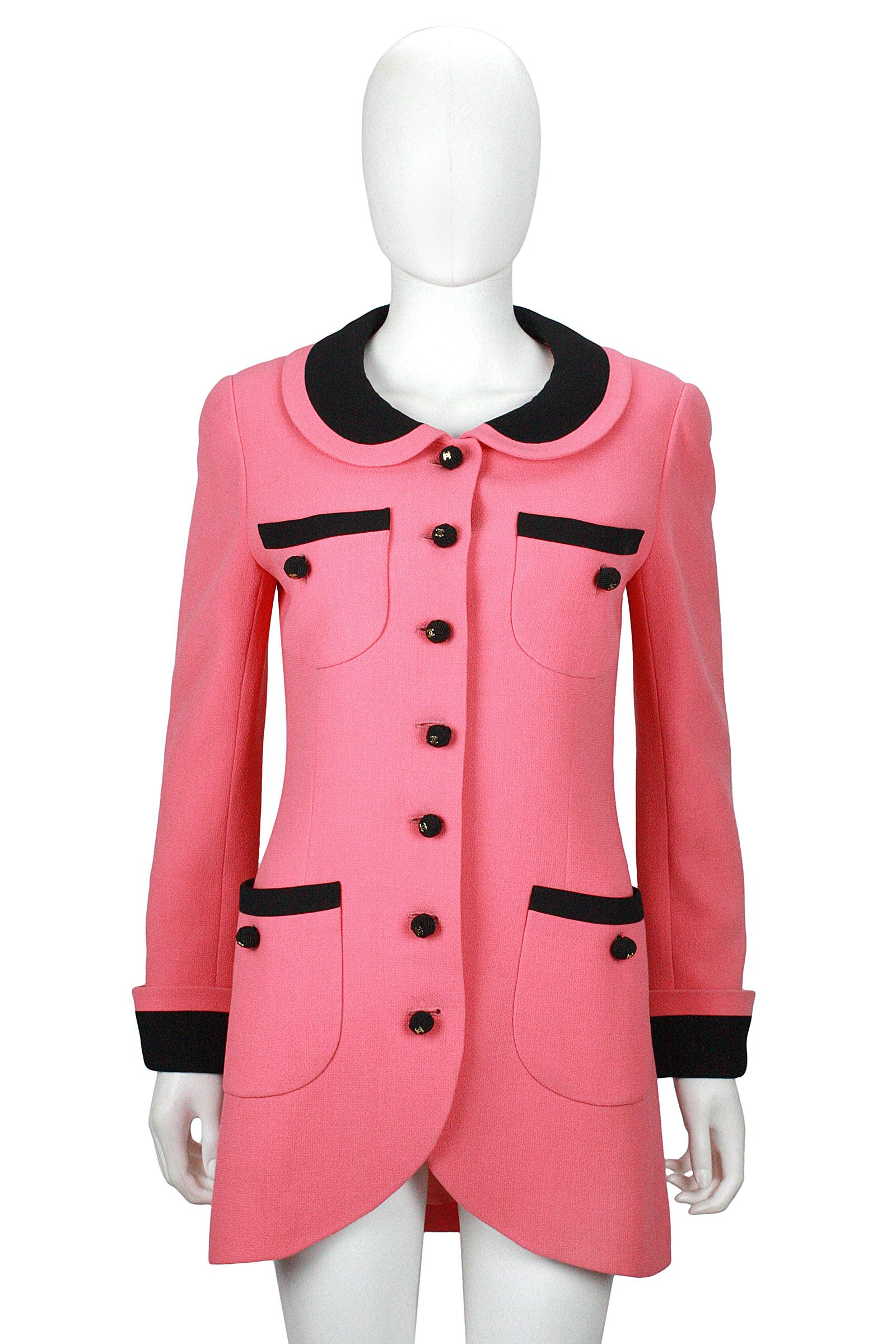 Chanel from the 1980s by Karl Lagerfeld, pink with black trim, long tailored jacket, or mini-dress.
It features a tulip hem, Peter Pan collar, cuffed sleeves and four our front pockets.
Decorated with black & gold double-C logo buttons.
Fully lined