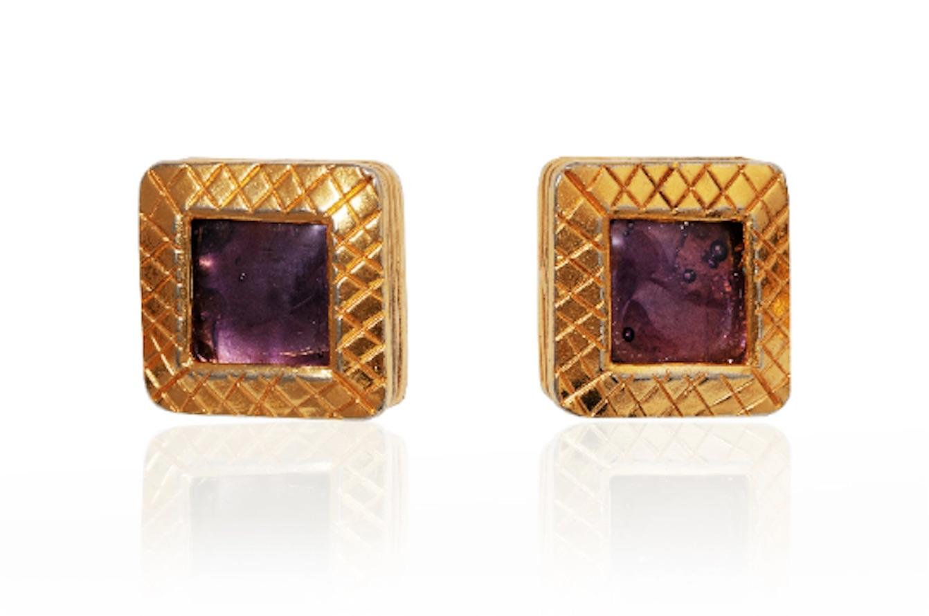 These 1980s Chanel earrings are in impeccable vintage condition and designed by Victoire de Castallane. They feature a raised square etched design and inset is a purple gripoix or hand poured glass stone. Each earring measures 2.5 cm in diameter and