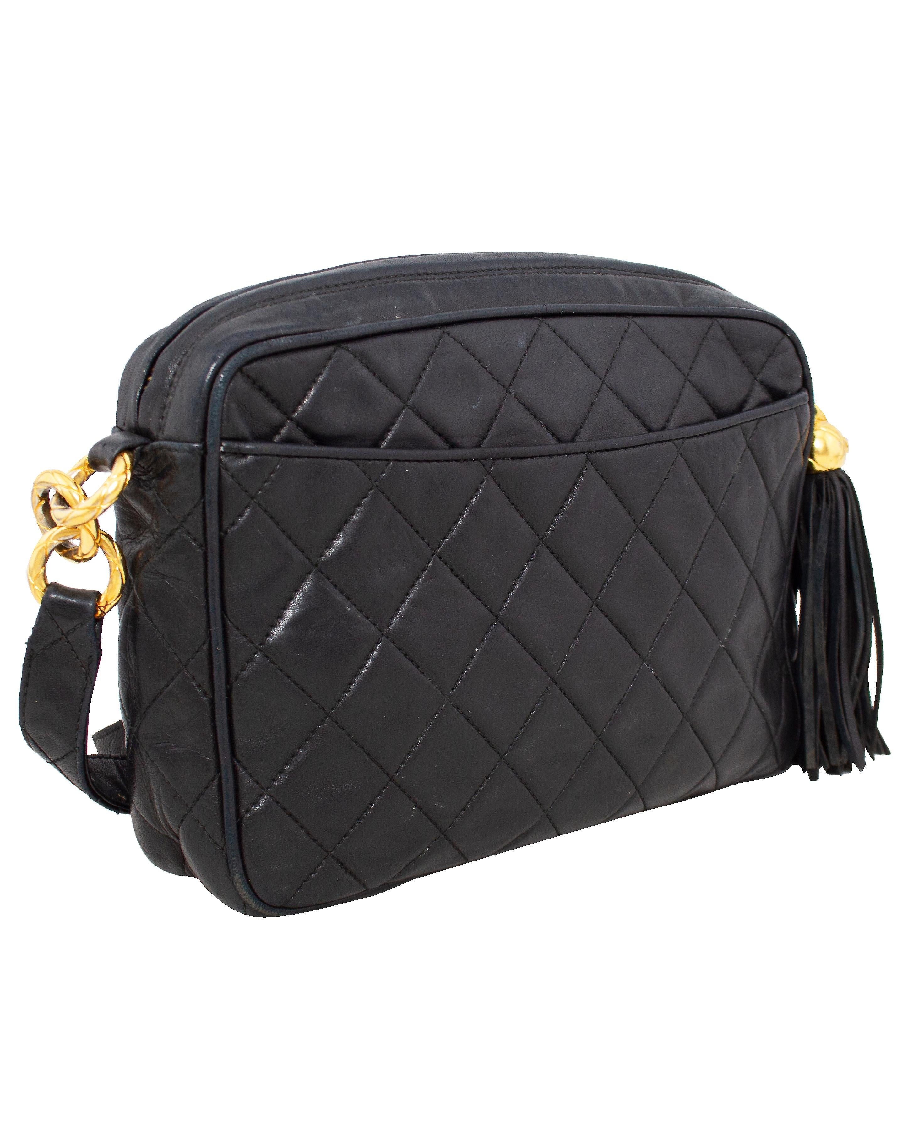 A classic and timeless Chanel bag from the 1980s. Black quilted leather with contrasting gold tone hardware and a quilted leather strap. This is such a great, functional, yet chic bag with open slit pockets on either side for easy access to things
