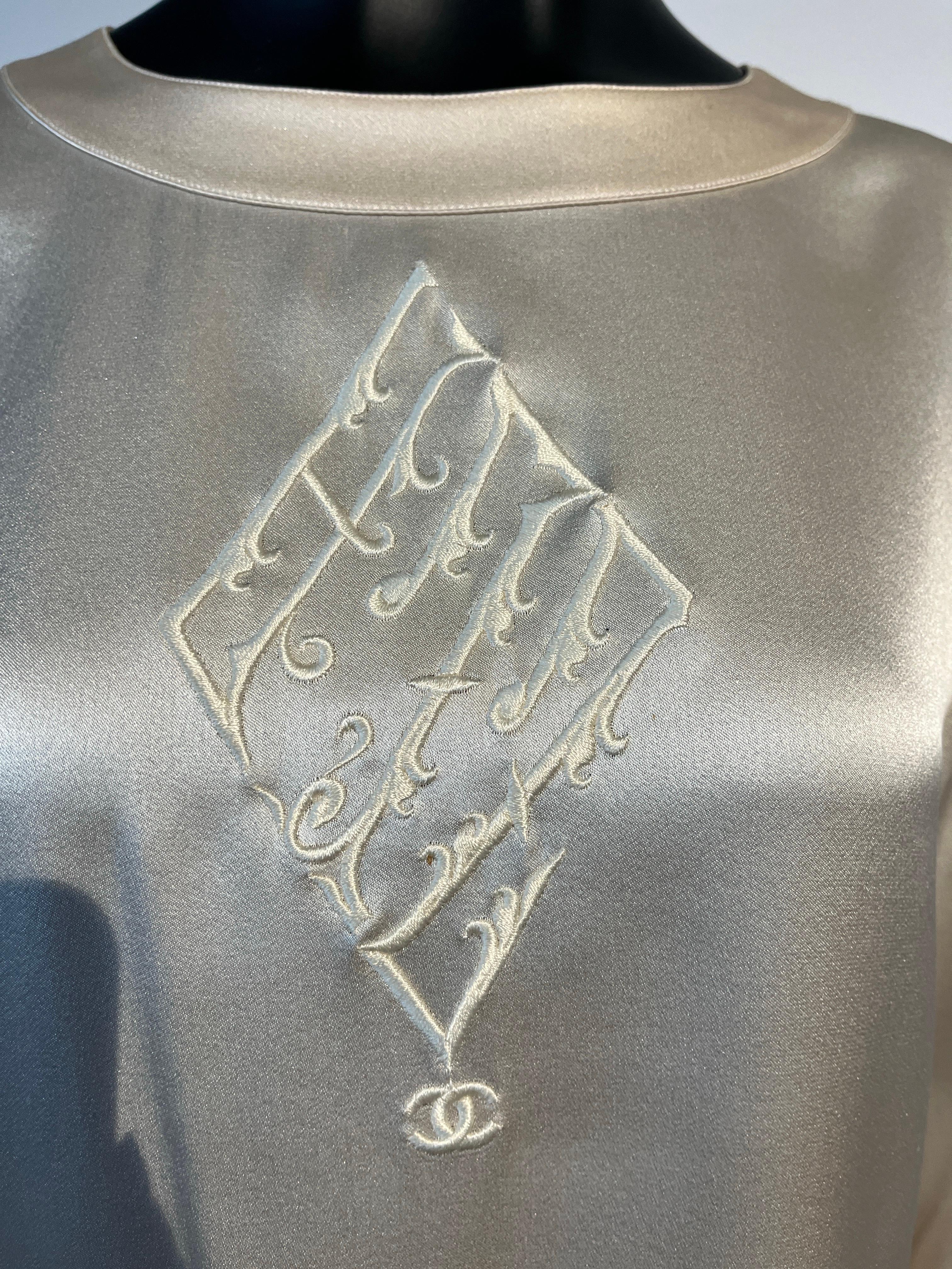 Una bellissima camicia vintage in raso di seta di Chanel degli anni '80.
Presenta bottoni di perle CC sul colletto e sui polsini e uno splendido ricamo frontale CC.

Il raso di seta color avorio è pesante e lussuoso. 

All'interno di questo articolo