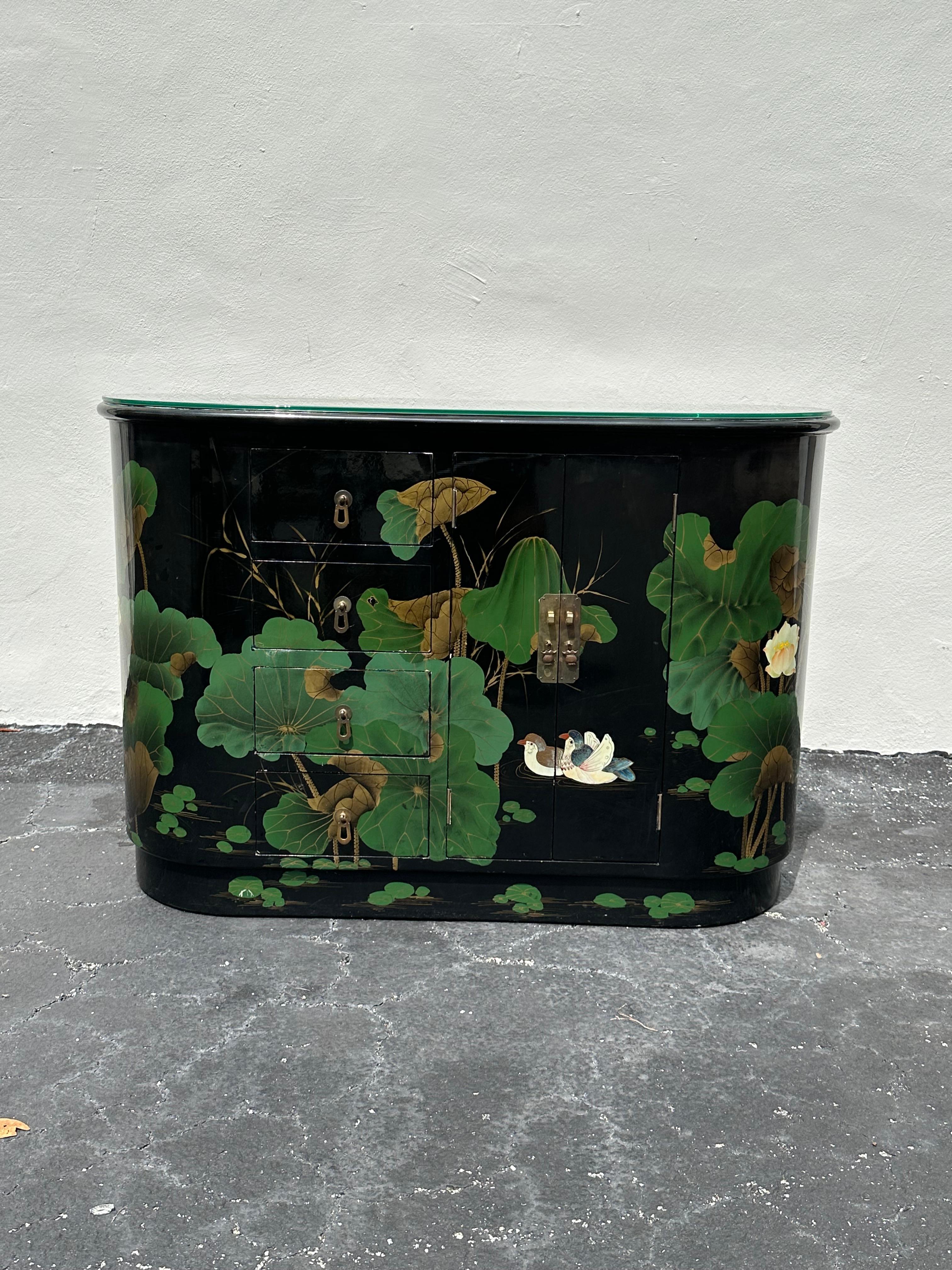 Transport yourself back to the sleek and sophisticated 1980s with this exquisite hand painted, lacquered, oval mini sideboard storage cabinet. The ultra rare sideboard gives an air of culture and refinement. Outstanding design is exhibited