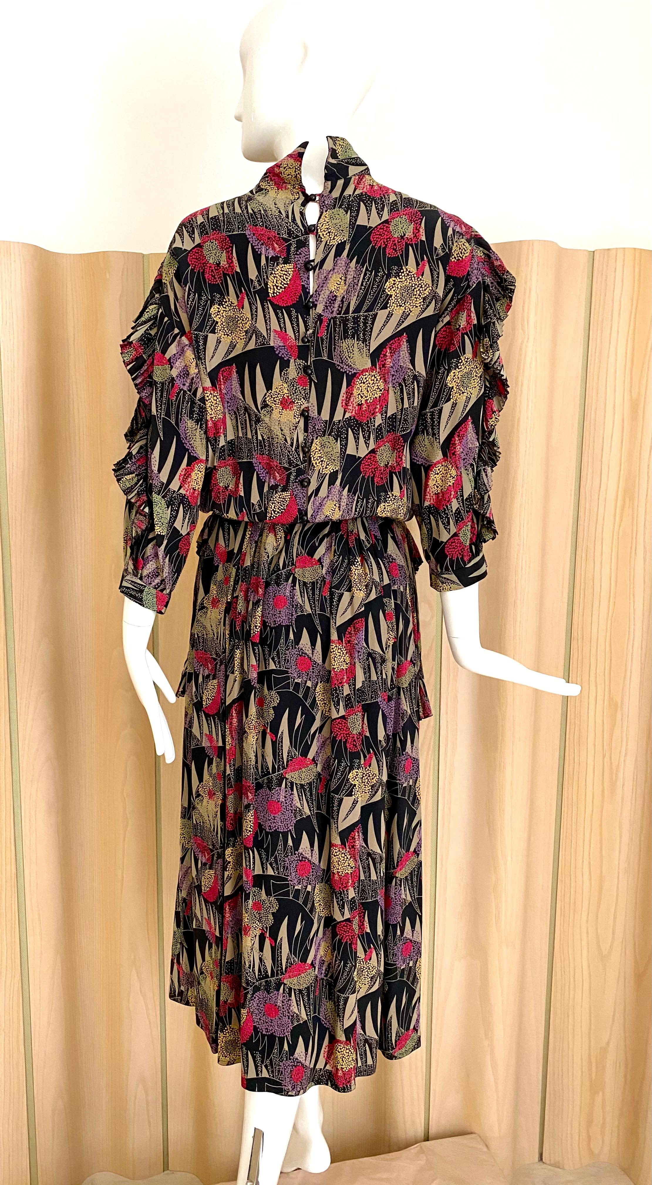 Chloe vintage de seda con estampado floral en rojo, morado y marrón con cuello nehru con mangas de volante.
Busto: 36