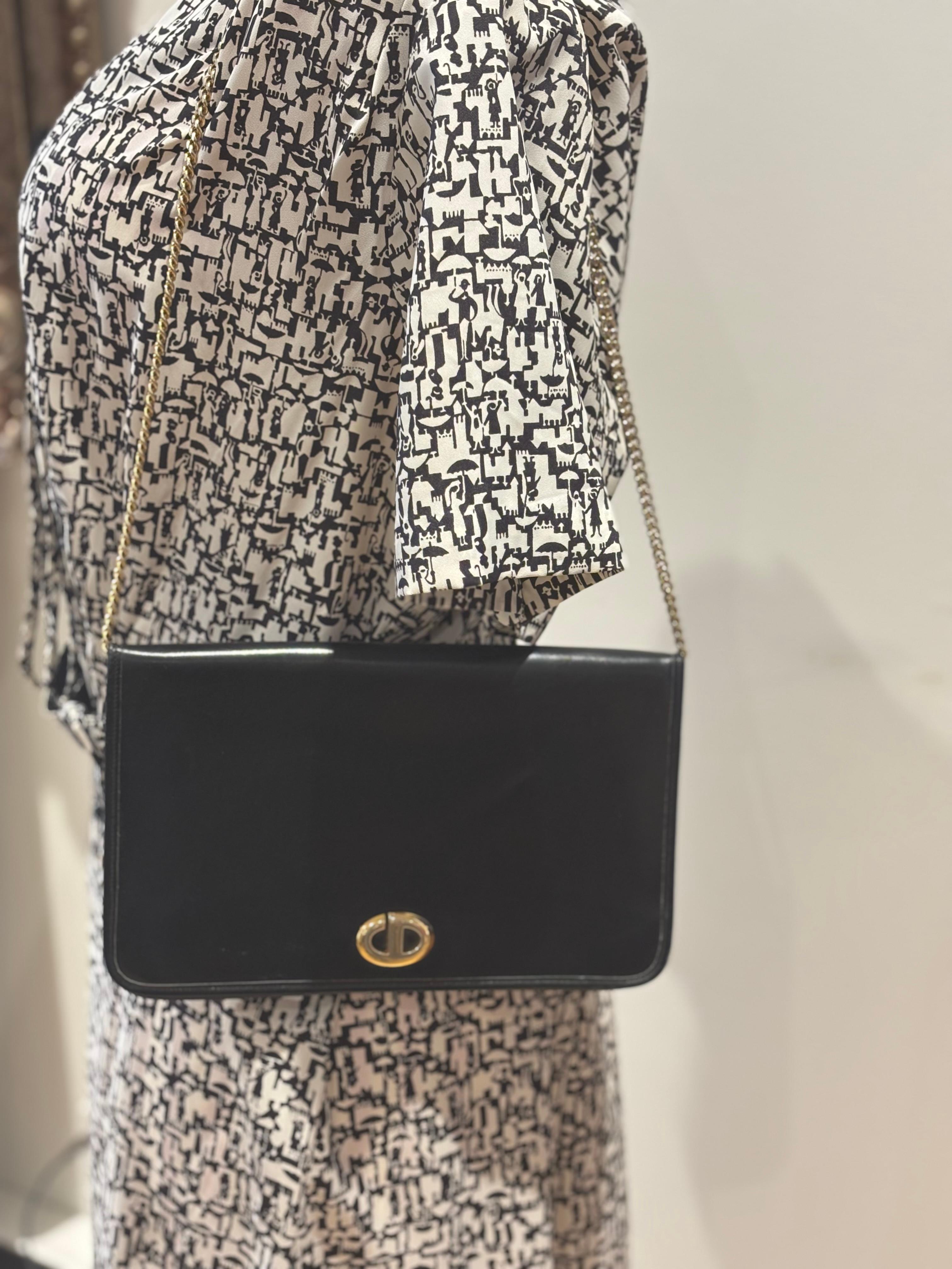 È incredibile che una borsa di 40 anni sia ancora in buone condizioni.
Questa borsa a tracolla Christian Dior in pelle nera è una classica borsa con patta di Dior. Ha una catena dorata e un CD dorato sul davanti.
Naturalmente c'è un po' di usura, ma