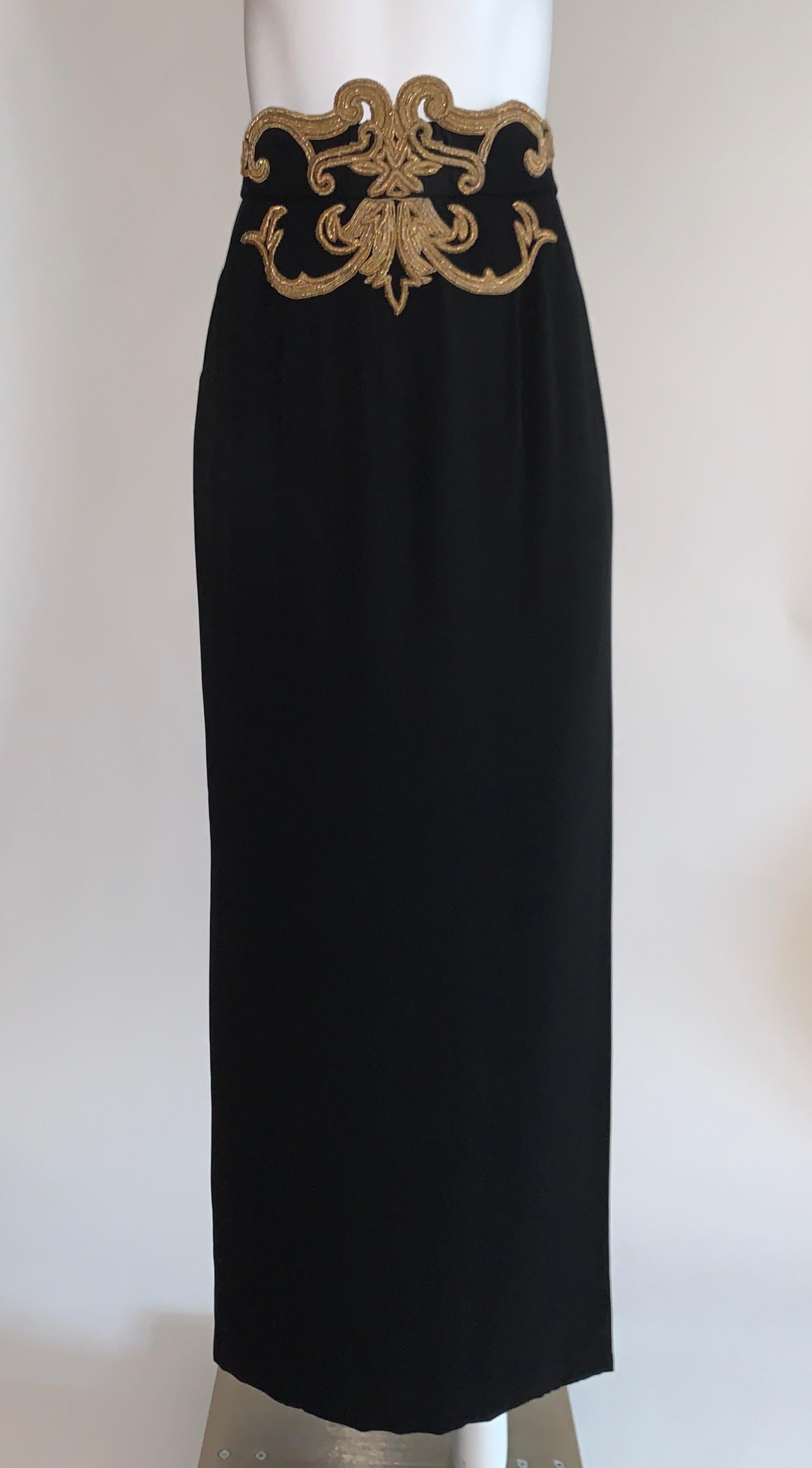 Vintage Christian Dior Boutique black straight maxi skirt with gold embellished detail at waist. Swirl detail consists of thick metallic wrapped threads and small beads. Long slit at side front allows movement. Back zip with two hooks.

No content