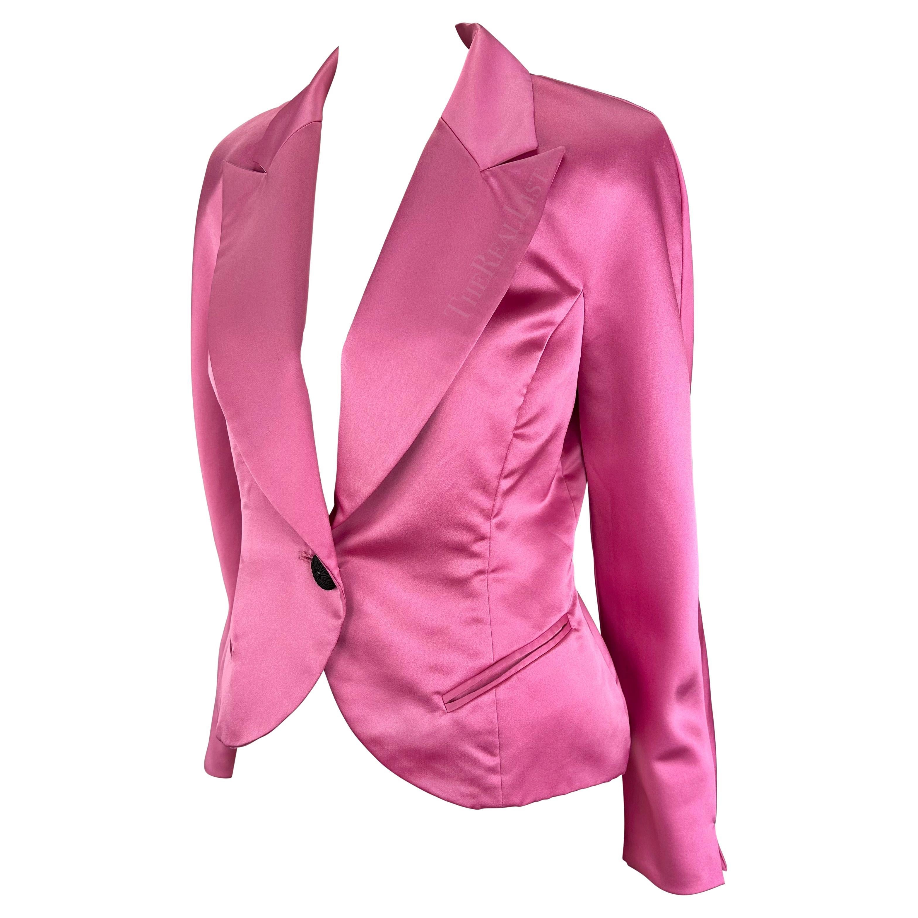 Presenting a fabulous hot pink satin Christian Dior blazer. From the 1980s, this blazer exudes a magnetic charm with its hot bubblegum pink satin fabric, emanating a stunning shimmer. The wide peak lapel and single black woven button closure enhance