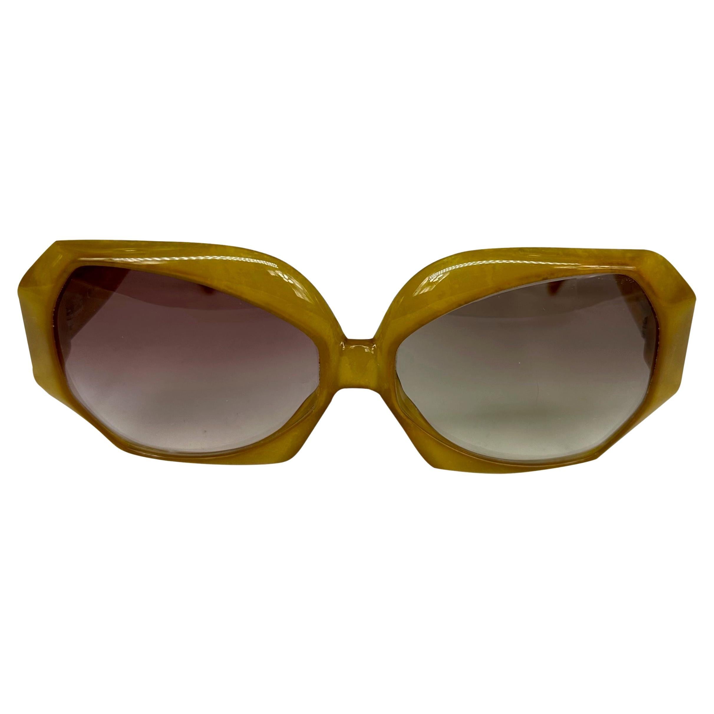 Nous vous présentons une paire de fabuleuses lunettes de soleil surdimensionnées Christian Dior. Datant des années 1980, ces lunettes de soleil couleur miel présentent une monture octogonale surdimensionnée et sont complétées par un logo rétro 