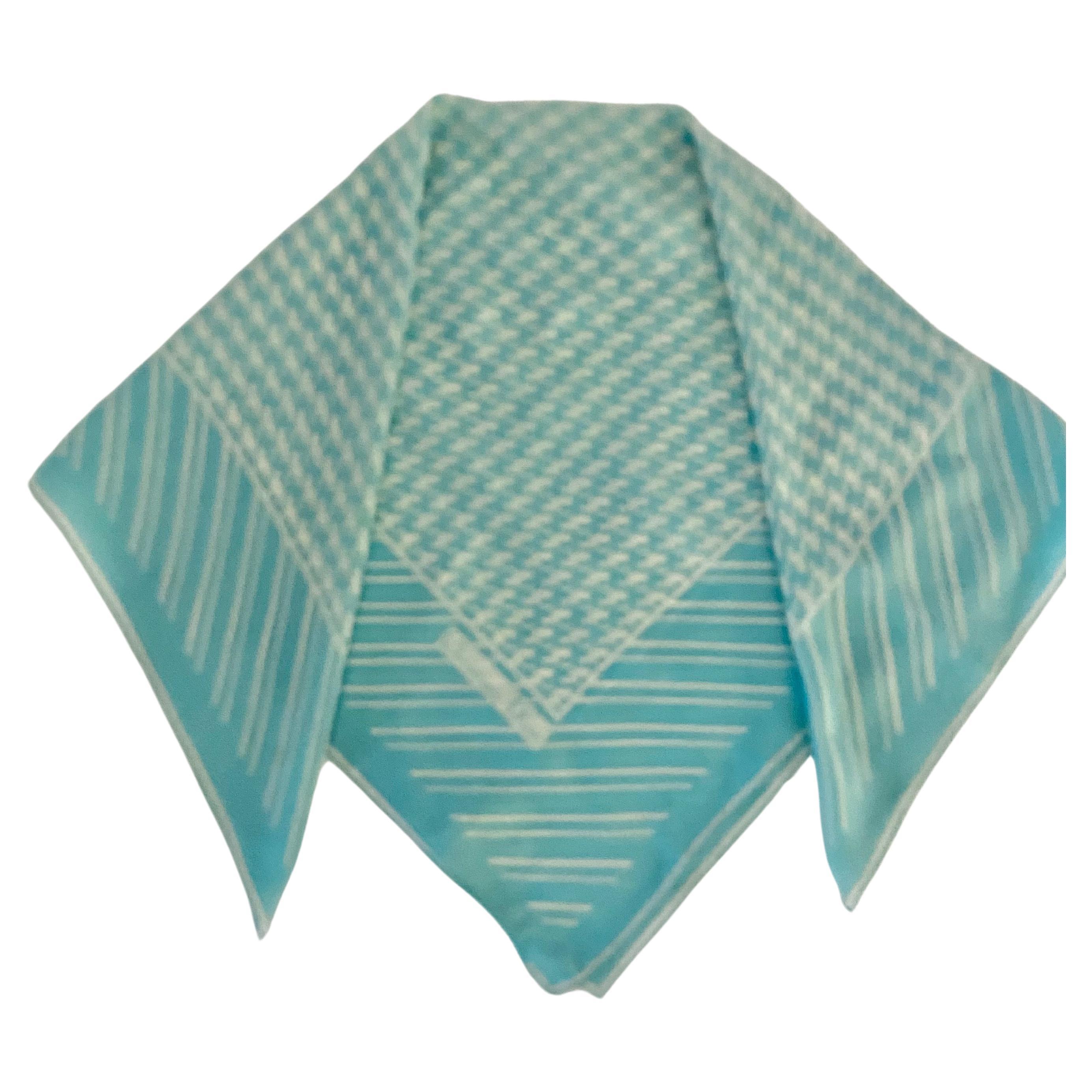 From the vintage '80s, this lavish houndstooth scarf made of 100% silk by renowned French designer Christian Dior is a luxurious delight. An exquisite light teal/turquoise hue and white stripes around the edge are graced with the signature Dior
