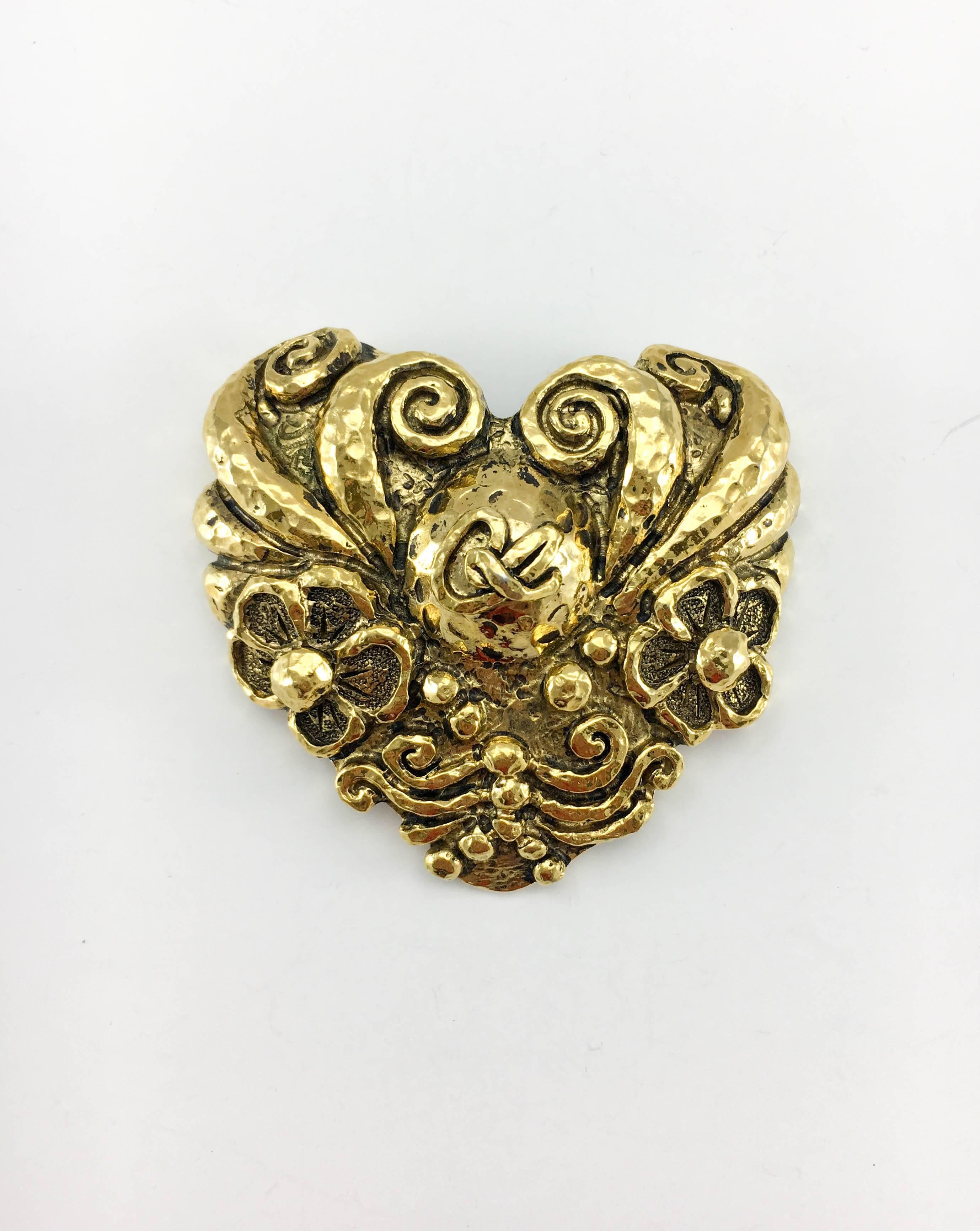 Vintage Christian Lacroix Large Gold-Plated Heart Pin Brooch. This striking brooch by Christian Lacroix dates back from the 1980’s. Crafted in gold-plated metal, this large heart-shaped brooch features the Lacroix logo in the centre surrounded by