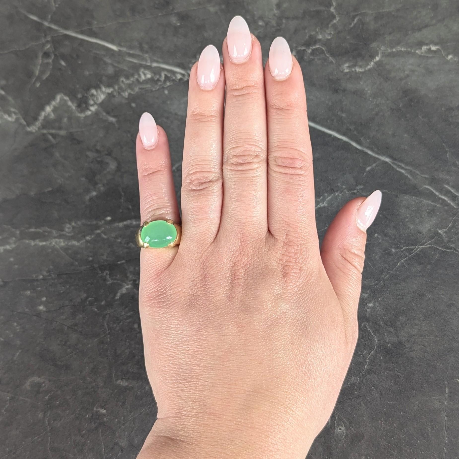 Centering an oval-shaped chrysoprase cabochon measuring 10.0 x 13.5 mm
Translucent vibrant light green with medium saturation
Prong set east to west - flanked by domed shoulders
Stamped for 18 karat gold
Circa: 1980s
Ring size: 4 and