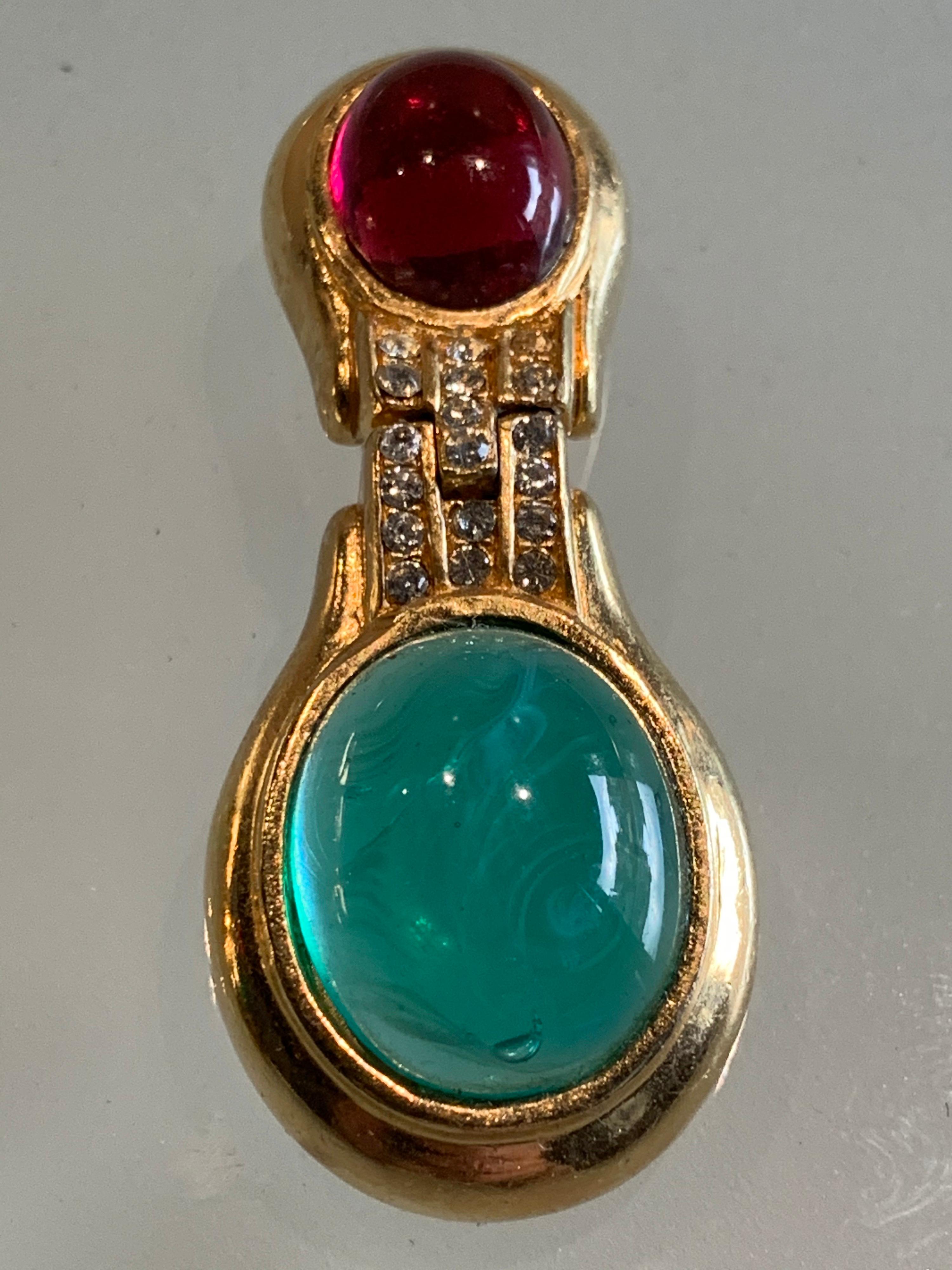 Beautiful 1980s Ciner Art Deco-inspired gold-tone clip-on earrings with jade green glass cabochon and smaller ruby red cabochon accented by smaller rhinestones. Hinged for movement. 