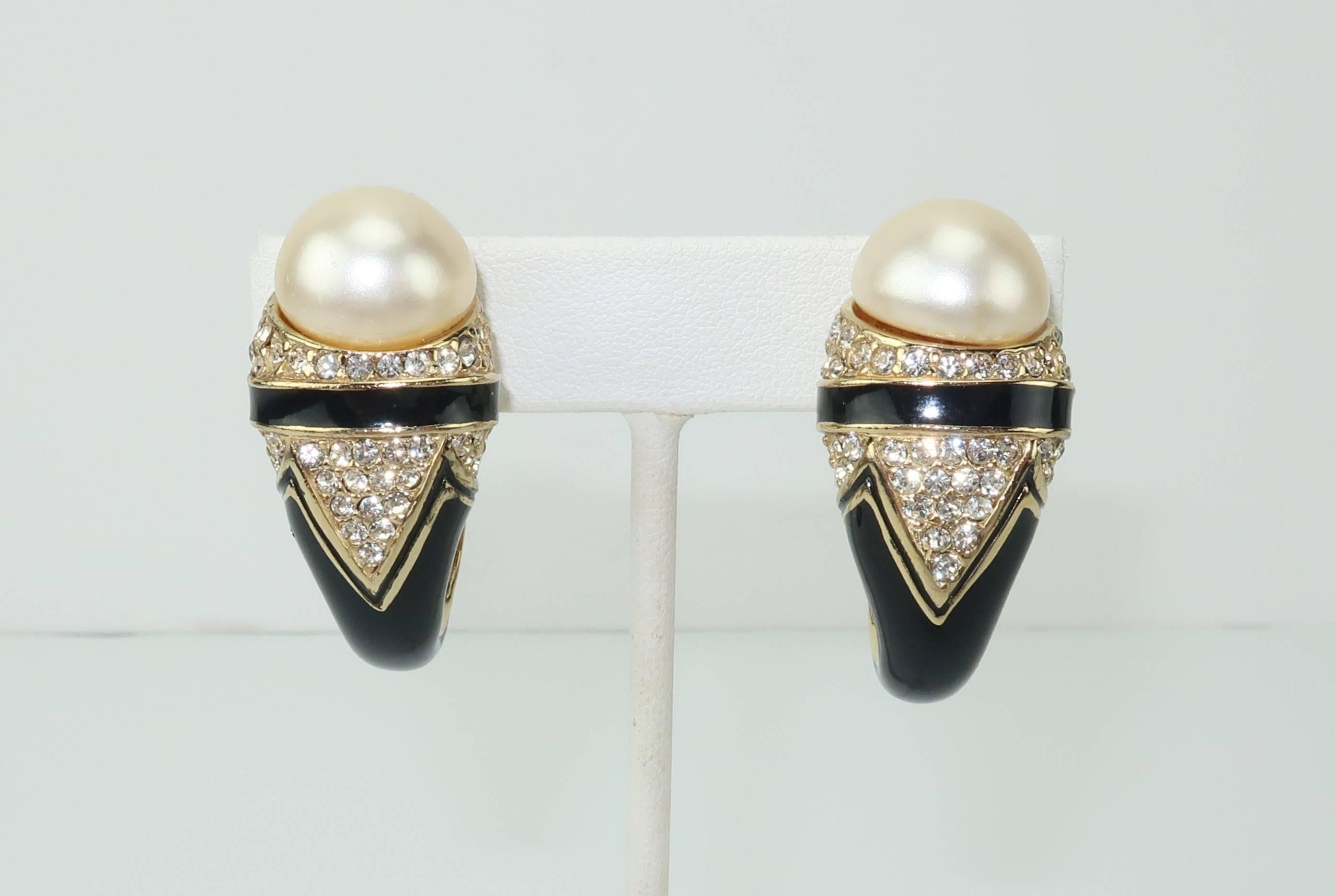 These 1980's clip on earrings are by Ciner, an American costume jewelry company known for producing high quality accessories since the 1930's.  The curved black enamel body with glamorous Art Deco styling is embellished with small crystal