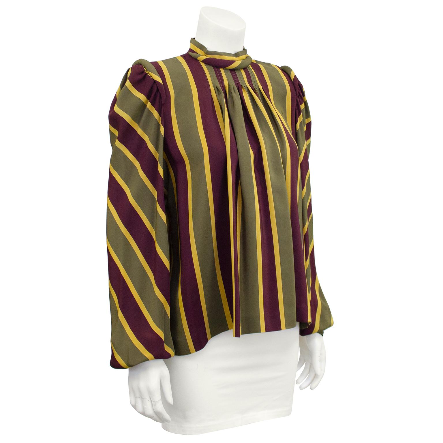 1980s Clementina Della Balda silk blouse. Olive green, burgundy and yellow vertical stripes run throughout the body and diagonal on the arms. Rolled details at neck and shoulders. Top stitching at bust with loose gathers that cascade into the