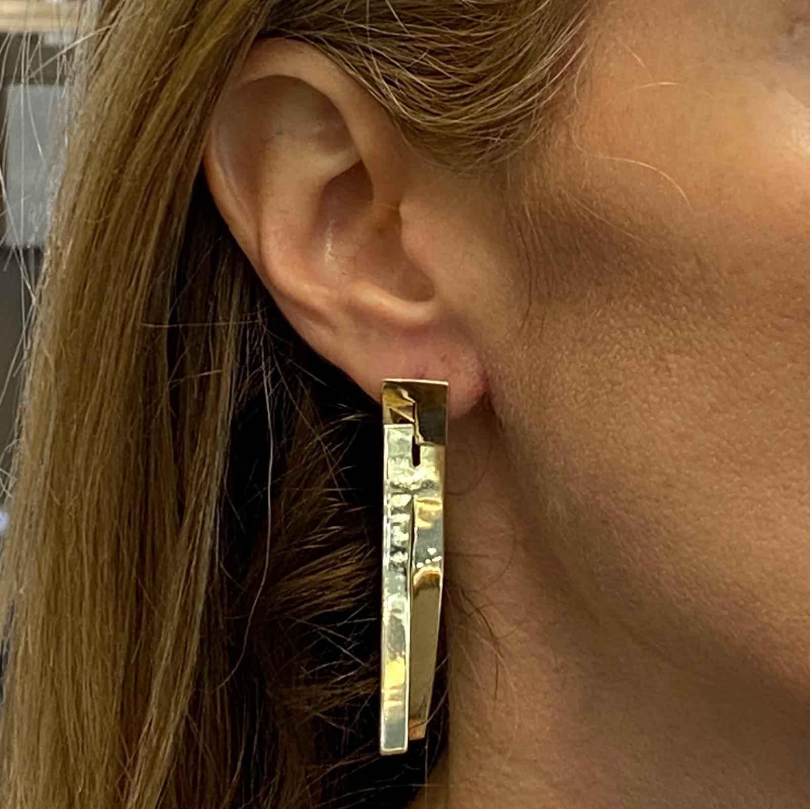 Fabulous rectangular dangle earrings fashioned in 18 karat yellow gold. The highly reflective light weight earrings measure 2.10 inches in length and .50 inch in width. 