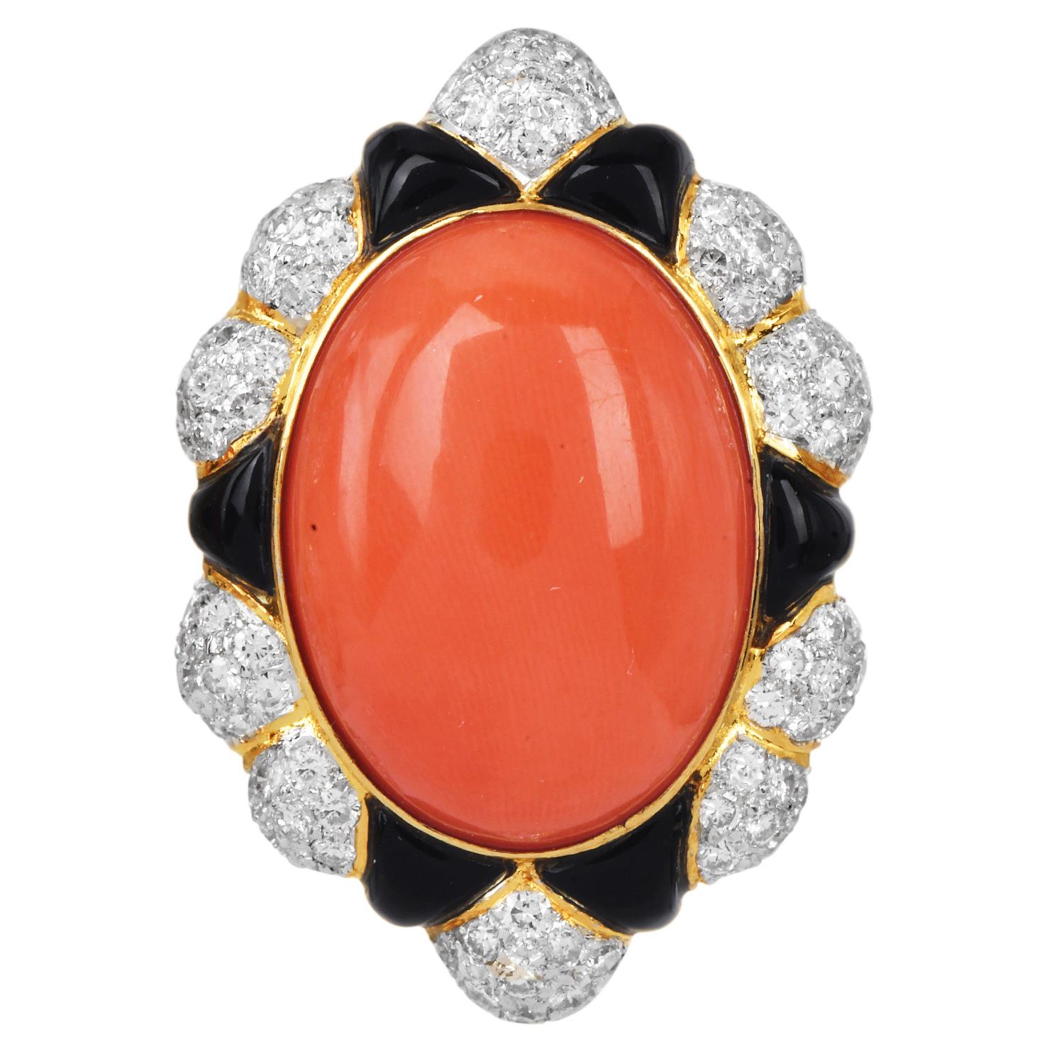 A vibrant and elegant pair of vintage earrings, beautifully crafted in finely textured 18K yellow gold. These bold summer-ready earrings feature oval-shaped natural salmon coral centers, surrounded by calibrated black onyx accents and approximately