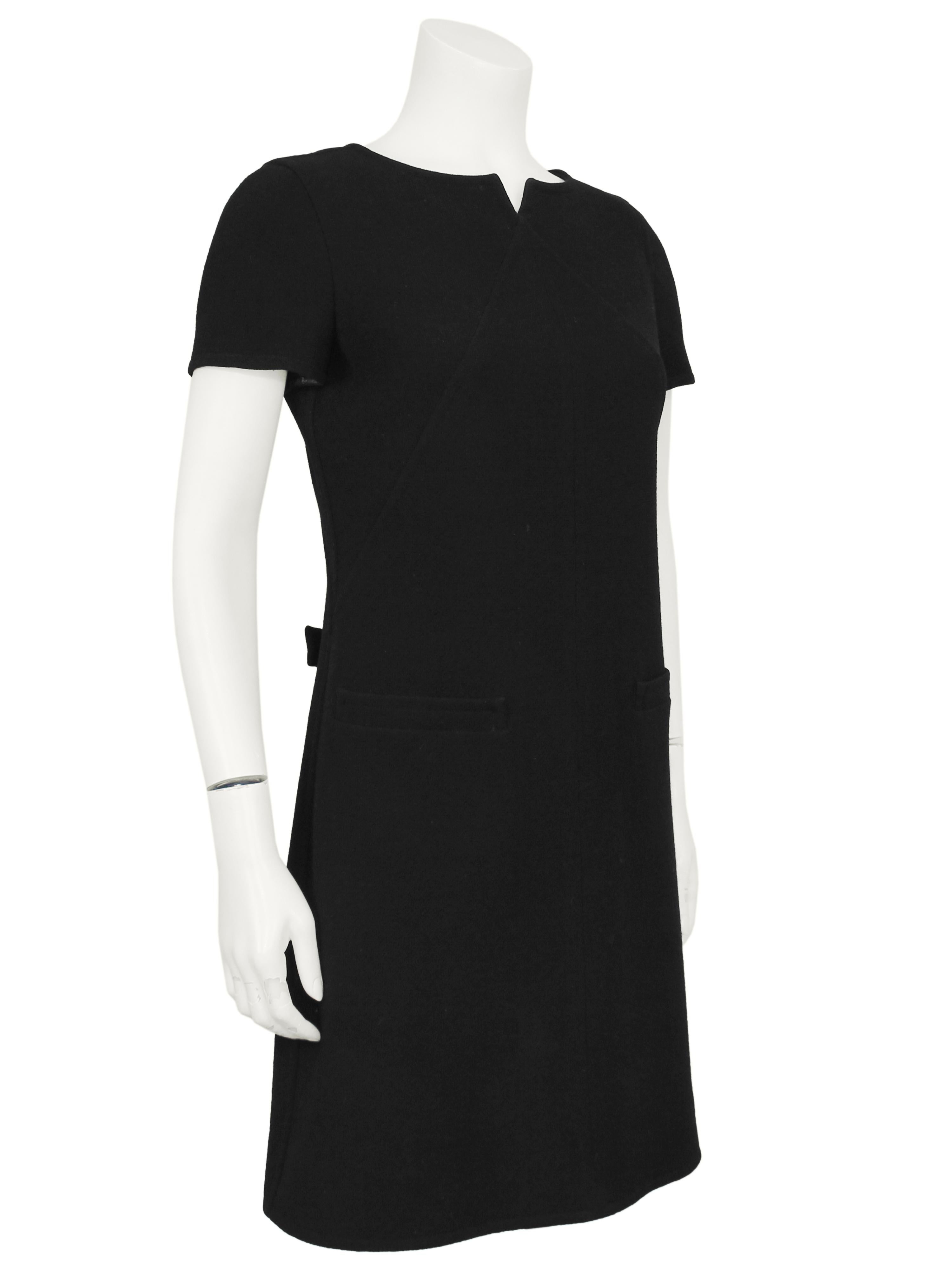 A Courreges classic with a twist, this LBD A-Line Mod shift dress is always in fashion. Short sleeves with a notched neckline, diagonal darts down the front and one seam down the middle and two faux pockets on the hips. Zips up the back, with a