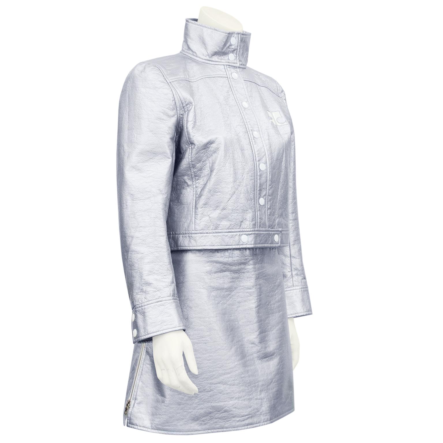 The ultimate Courreges 80’s revival look. Iconic silver vinyl Courreges biker jacket and matching mini skirt. Jacket is cropped with standing collar, white snap closures, and white Courreges logo on left side of bust. White lining with small all