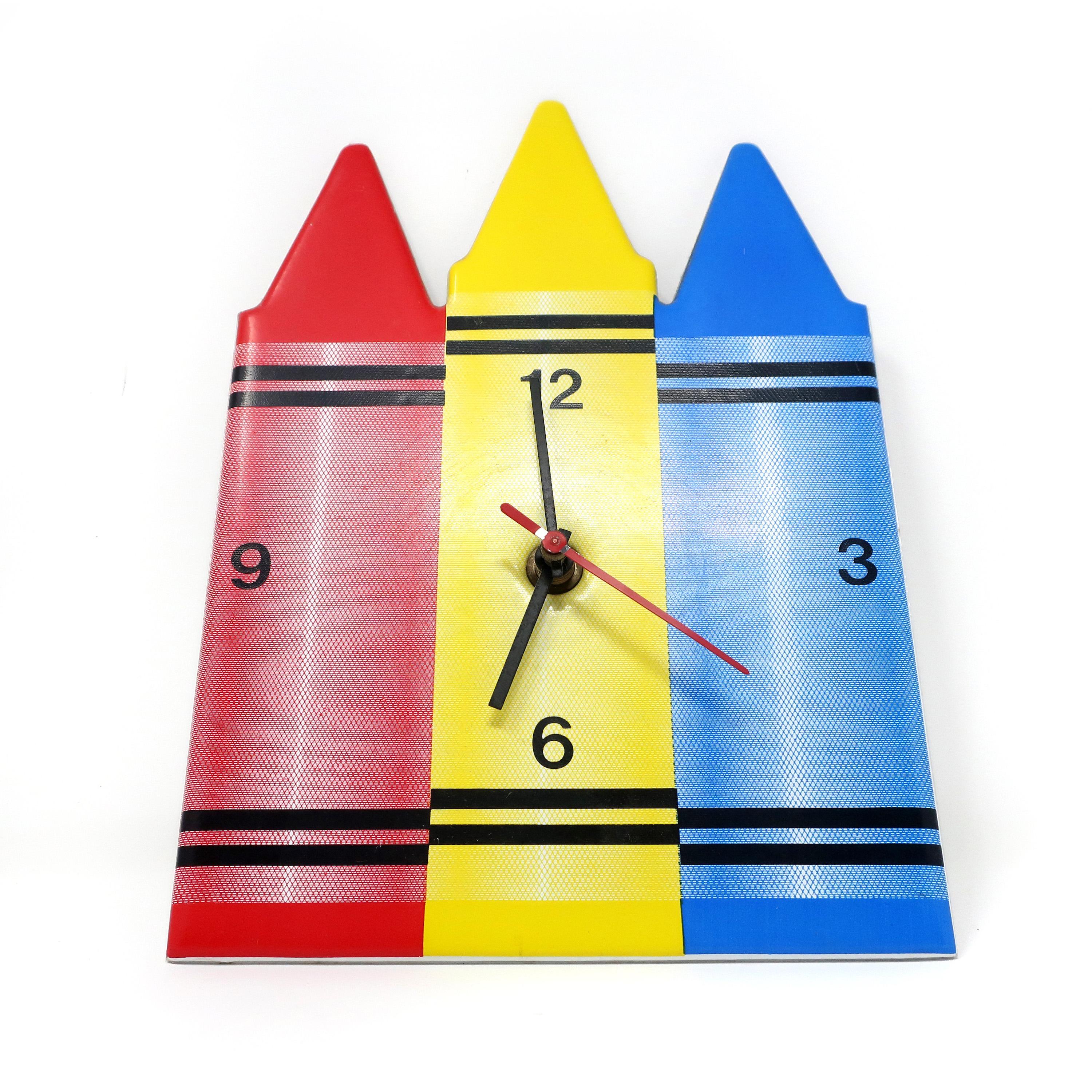 A vintage 1980s wall clock in the shape of multi-colored crayons by Small World Greetings. Three crayons: one red, one blue, and one yellow. In very good vintage condition with wear consistent with age and use, including two small paint loss spots