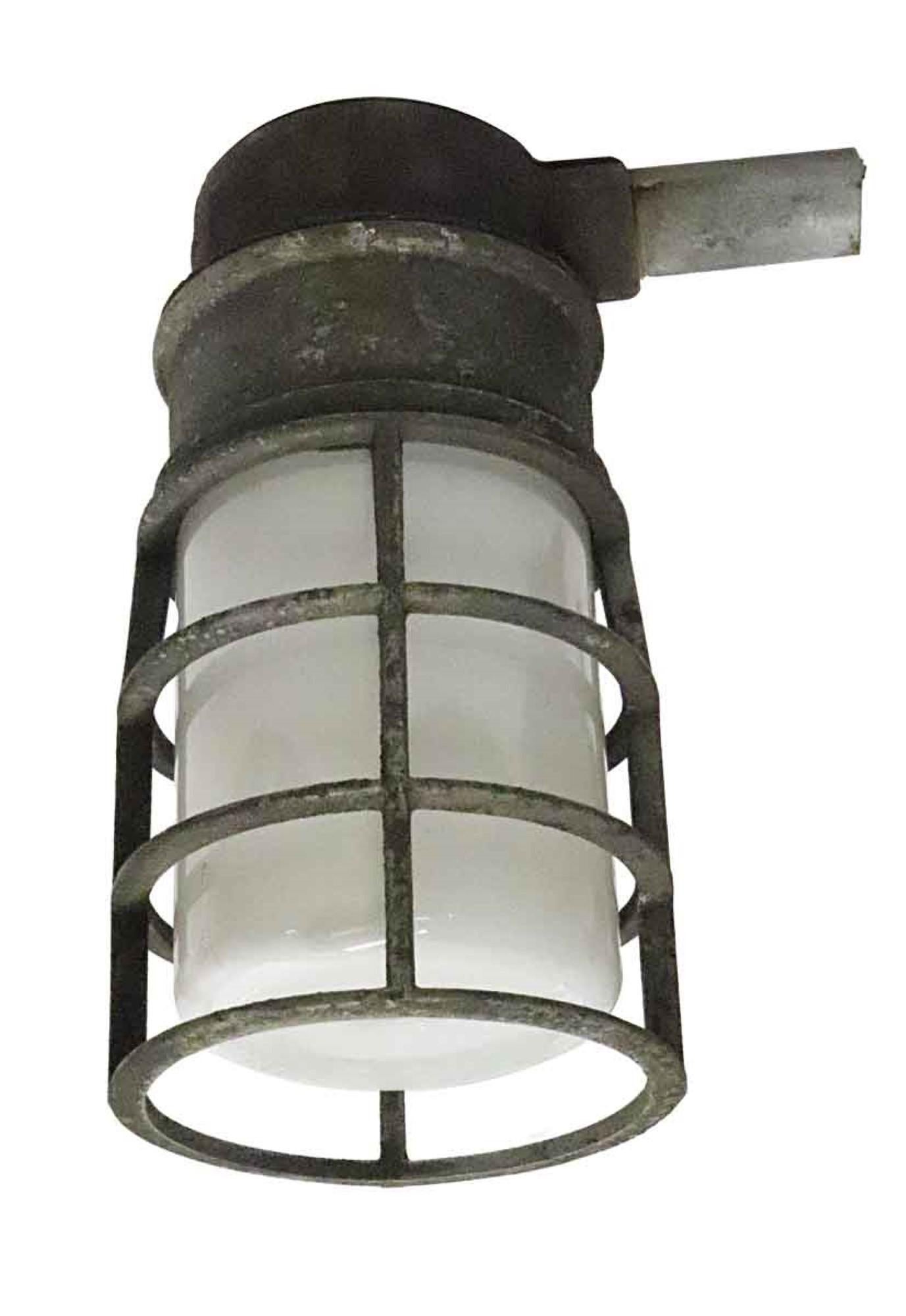 1980s Crouse Hinds industrial lights with white frosted glass shades and steel cages. Sold as a set of four. Will be rewired when purchased. This can be viewed at our Scranton, Pennsylvania location. Please inquire for the exact address.