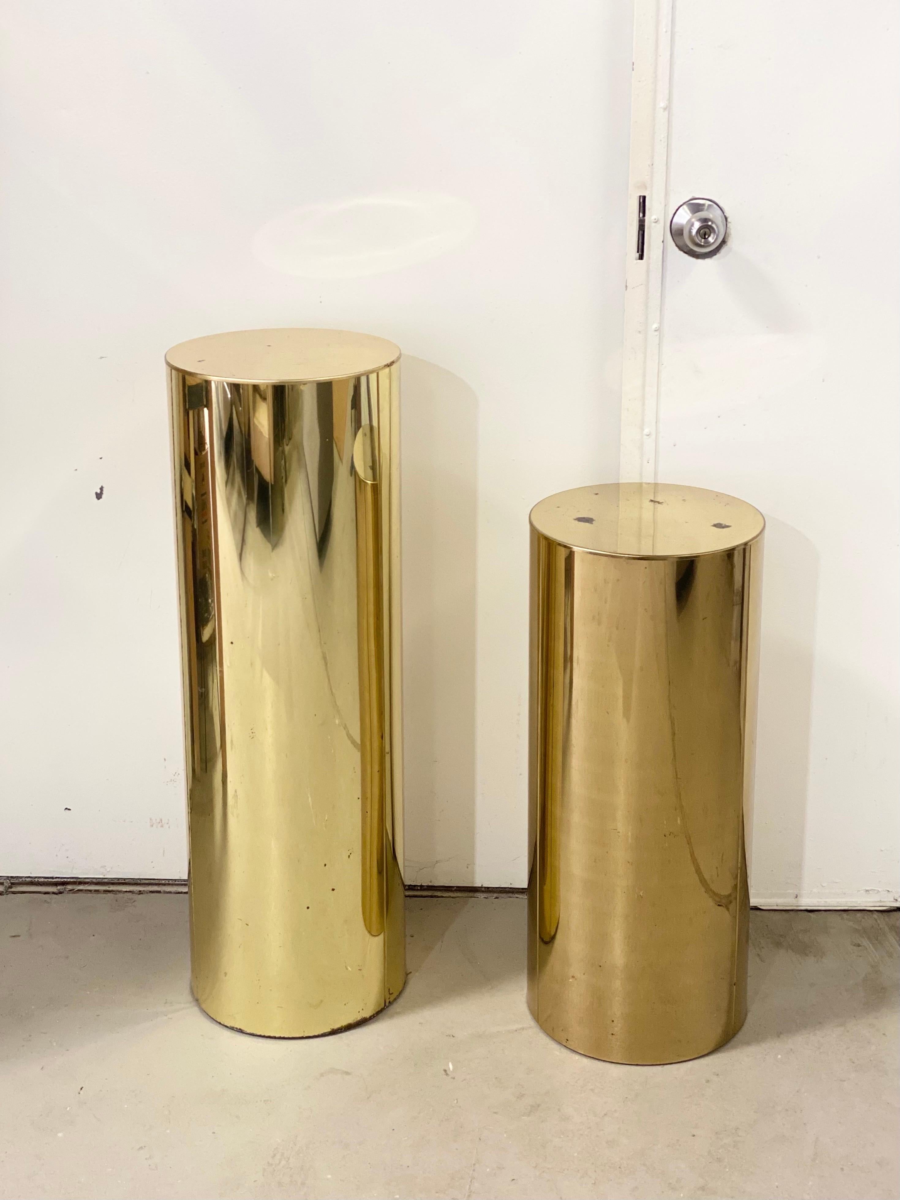 We are very pleased to offer a set of two modern pedestals by Curtis Jere, circa the 1980s. These brass cylinders with a shiny, reflective surface are a Classic midcentury design and a testament to modern simplicity. The pedestals provide an elegant