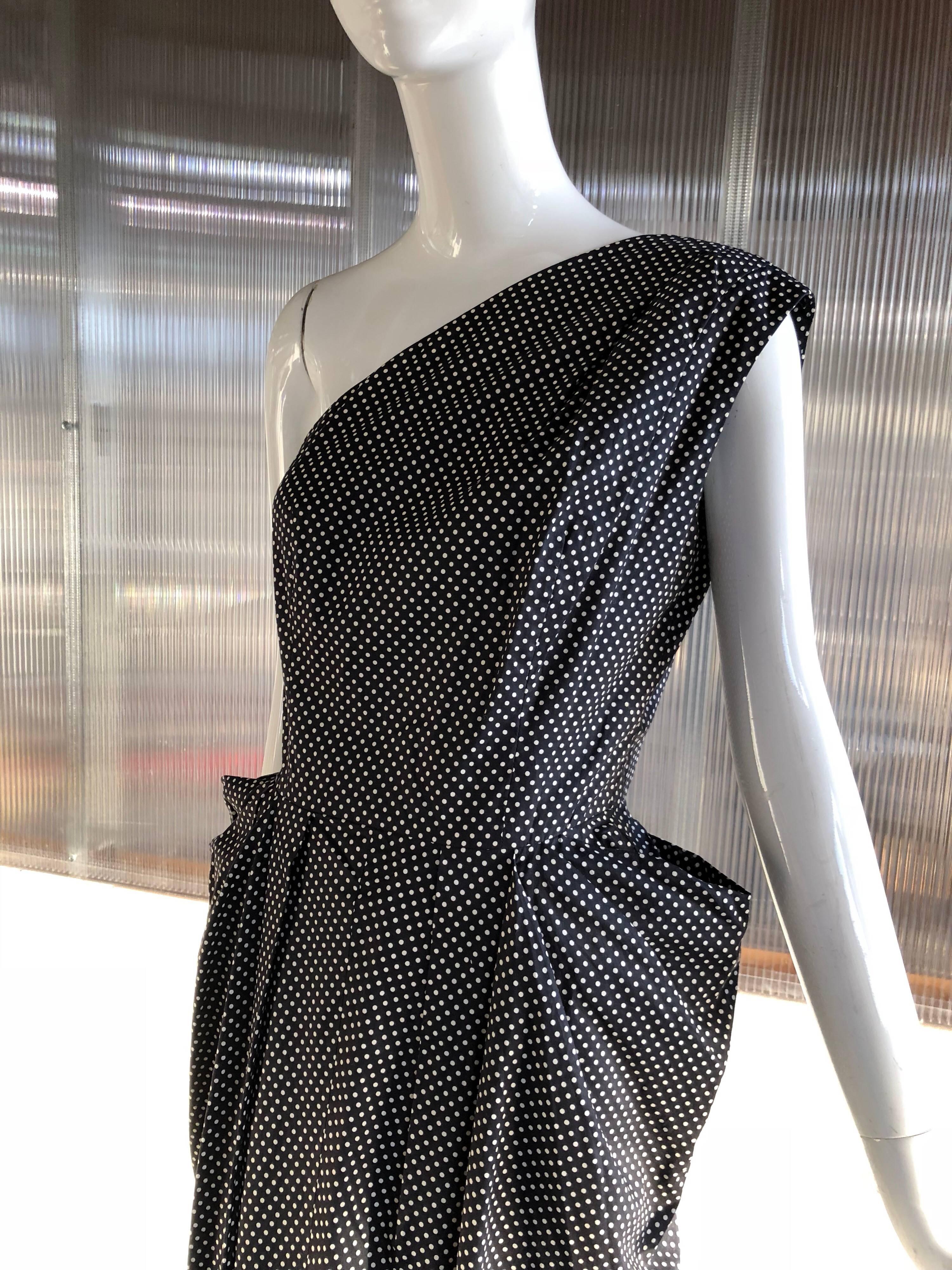 A beautiful 1980s custom-made-in-San-Francisco silk blend black and tiny white polka dot one shouldered cocktail dress:  Fully lined.  Features a beautiful horsehair stiffened draped hip treatment.  Boned bodice. 