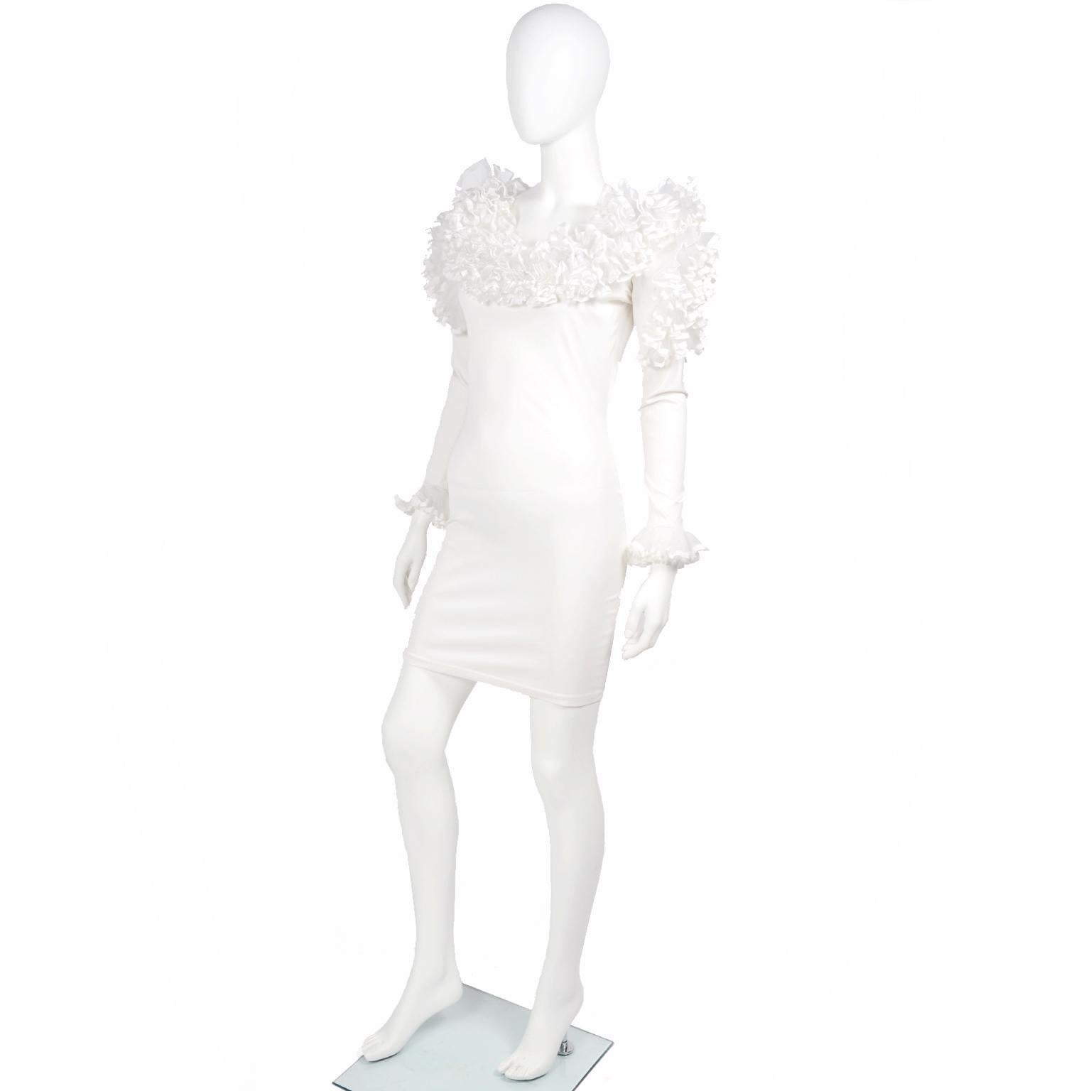 This is a dramatic bodycon 1980's vintage white statement dress from Dana Deatherage. This vintage lycra dress has white ribbon trimmed ruffled tulle that extends around the shoulders, on the upper part of the outer sleeve, and around the cuffs.