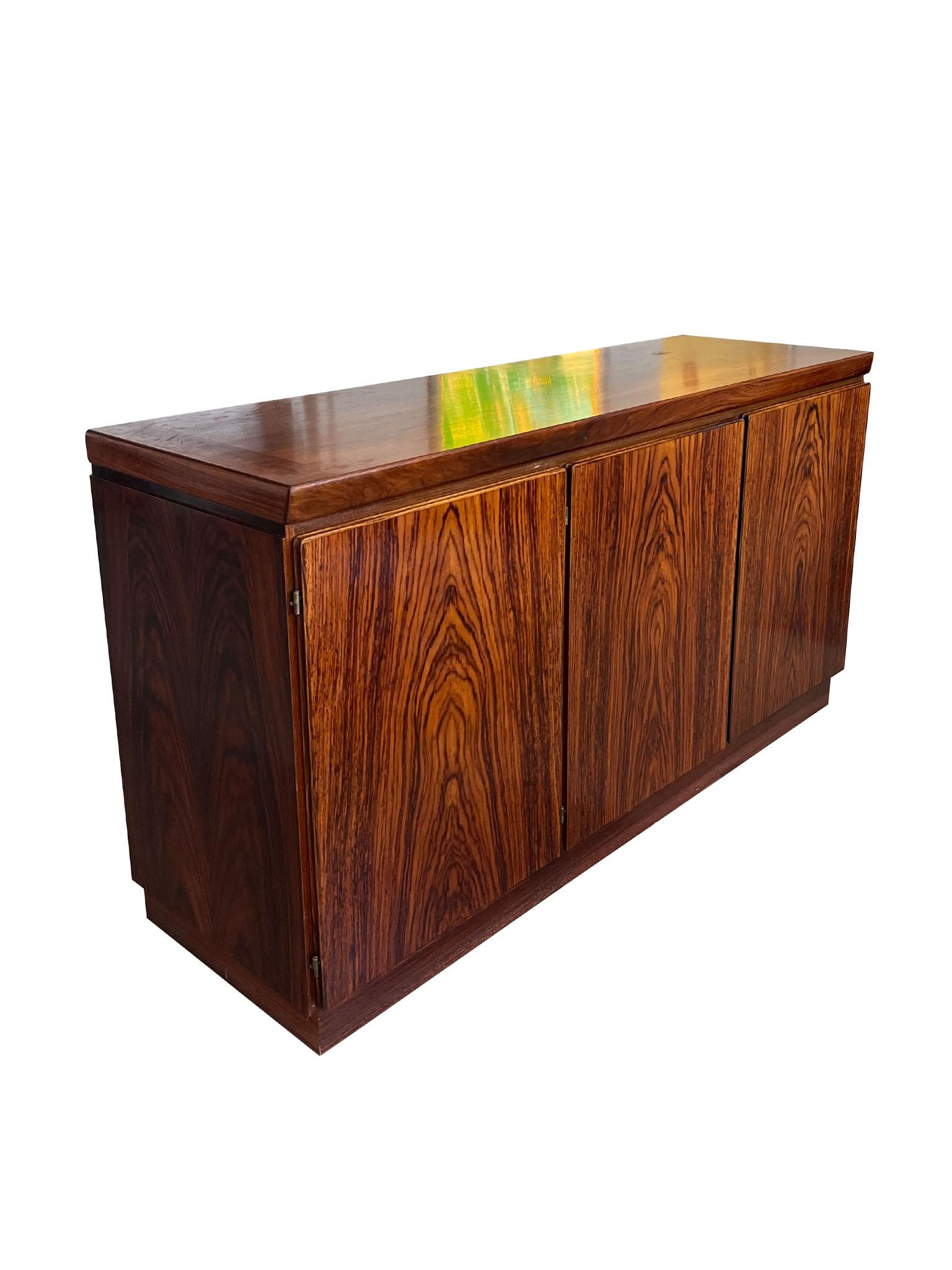 Favolosa e funzionale credenza moderna danese di Drylund, circa 1980. Il pezzo è dotato di tre armadi funzionali, di cui due a destra con vani aperti e uno a sinistra con 4 ampi vani per l'archiviazione, e uno a sinistra con cassetti incassati con
