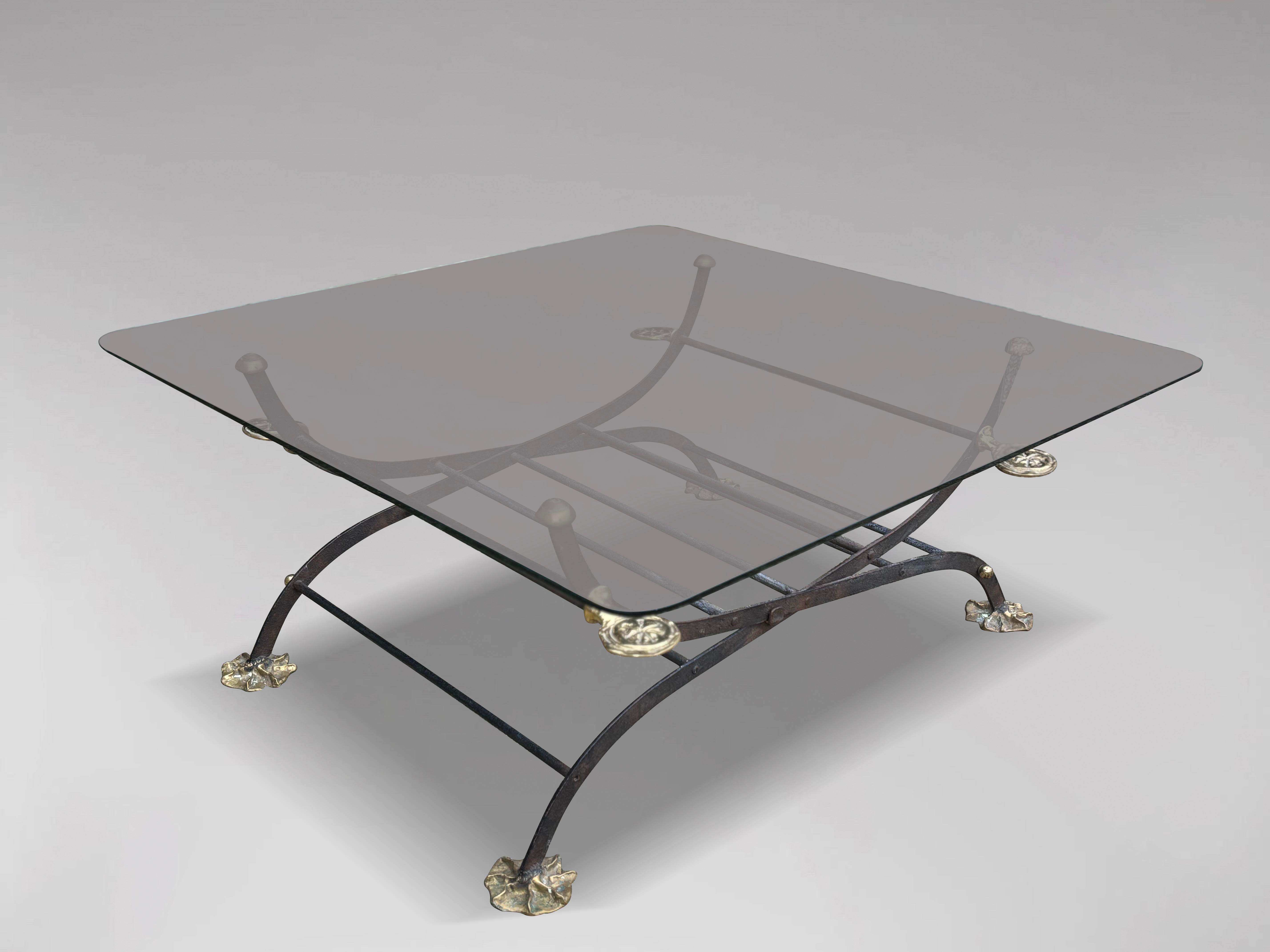 A large square coffee table by David Marshall, comprising a wrought iron folding base with bronze bases and carved brass additions below a square glass top. Extraordinary design, all original and signed with monogram.

The dimensions are:
Height: