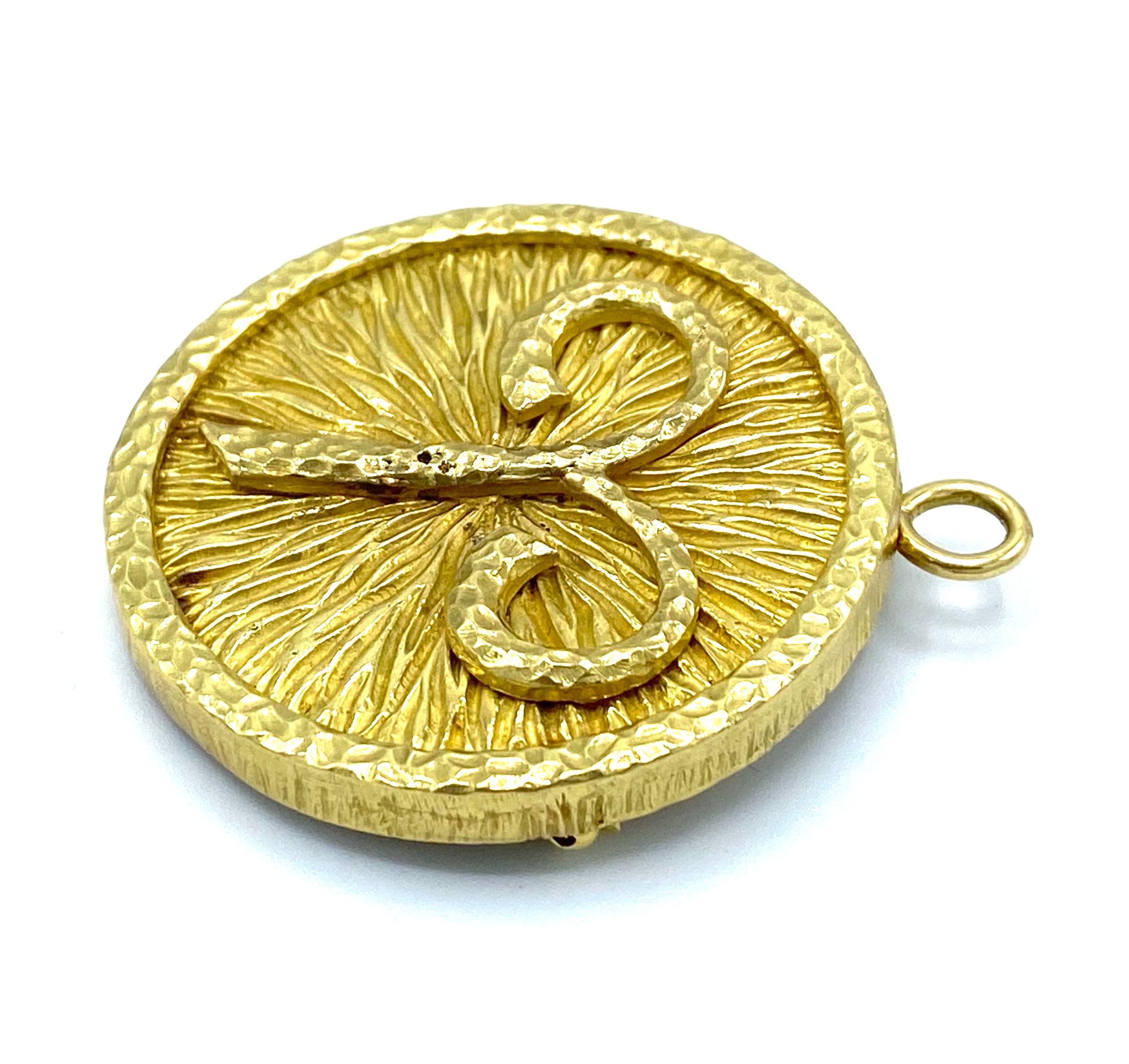 Product details:

The pendant is designed by David Webb, it is made out of 18 karat yellow gold. The pendant features hammered and textured gold finish with astrological sign Aries. The bail folds back for when you want to use it as a brooch. It is