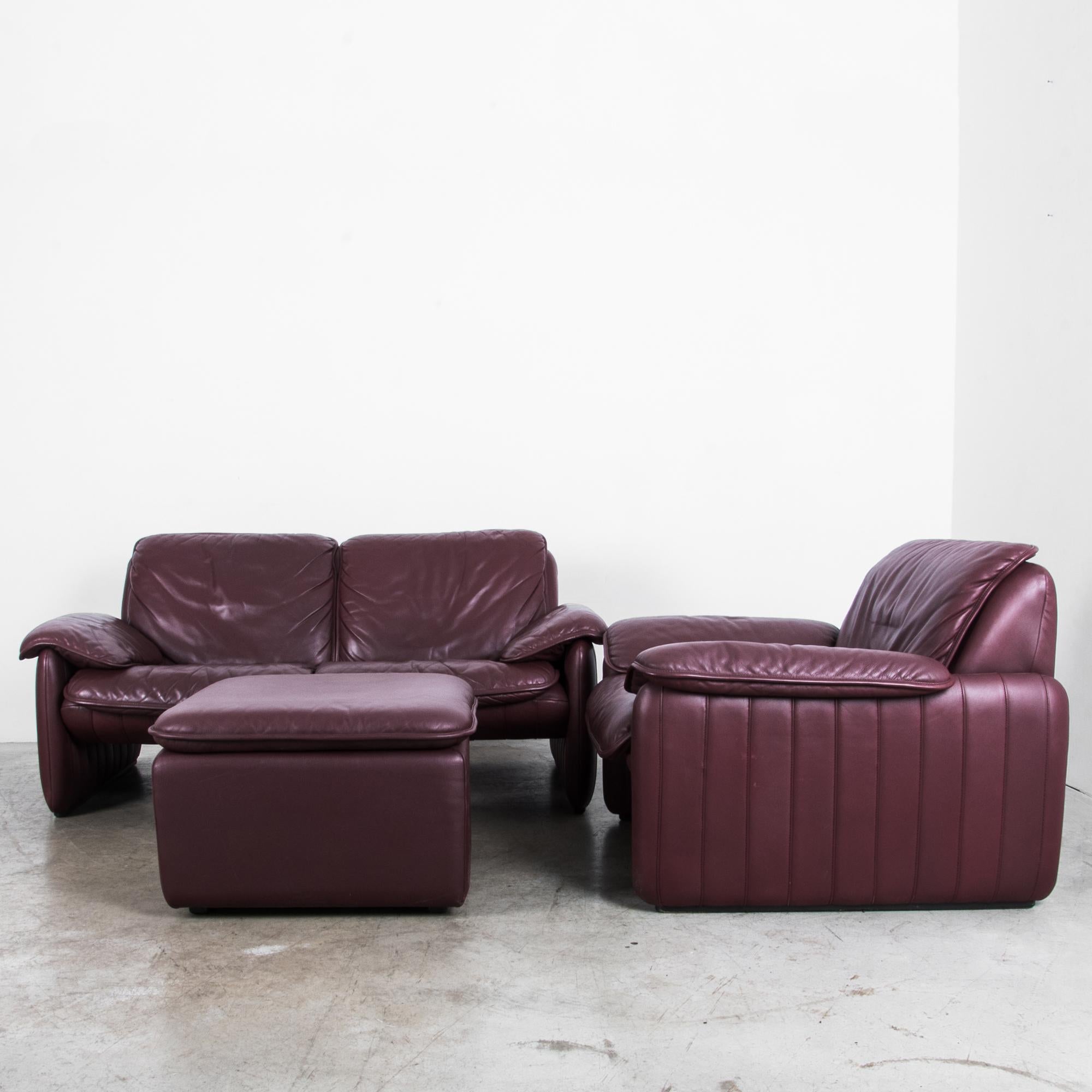 A De Sede leather sofa set featuring loveseat, armchair and ottoman. Made in the 1980s by Swiss furniture maker De Sede, known both for their leather craftsmanship and their contemporary designs. This sofa set features a rounded, modern silhouette.