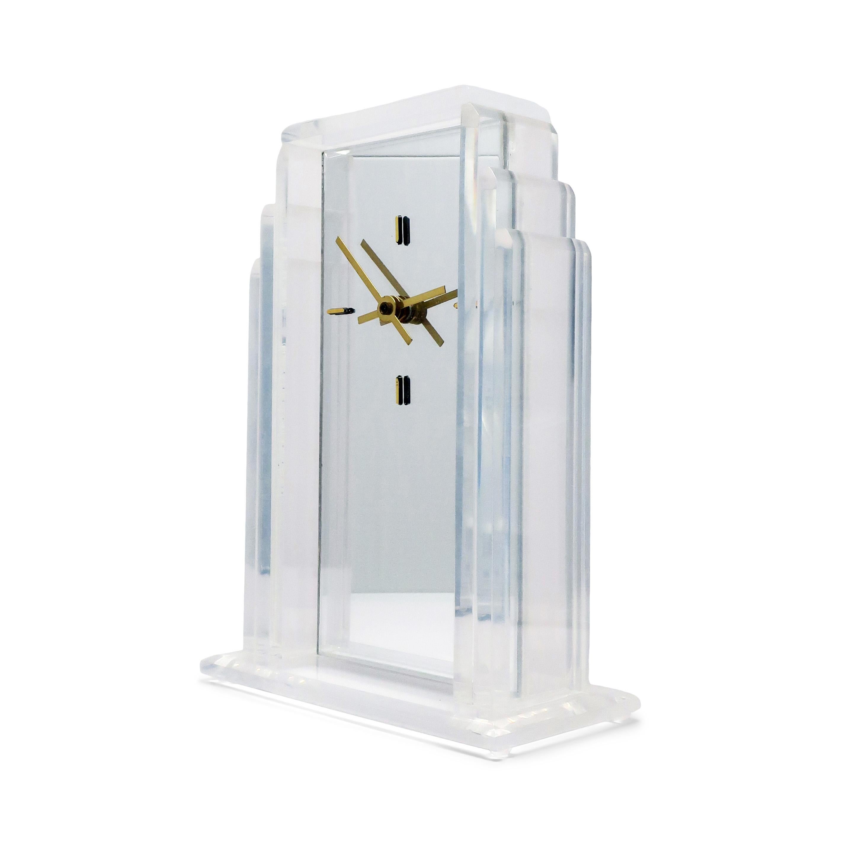 A lovely Art Deco-inspired lucite desk or mantle clock with lucite body and base, mirrored face, brass hands, and brass marks at 3, 6, 9, and 12.

In good vintage condition with wear consistent with age and use. Unsigned.

7.5“ x 3” x 10”