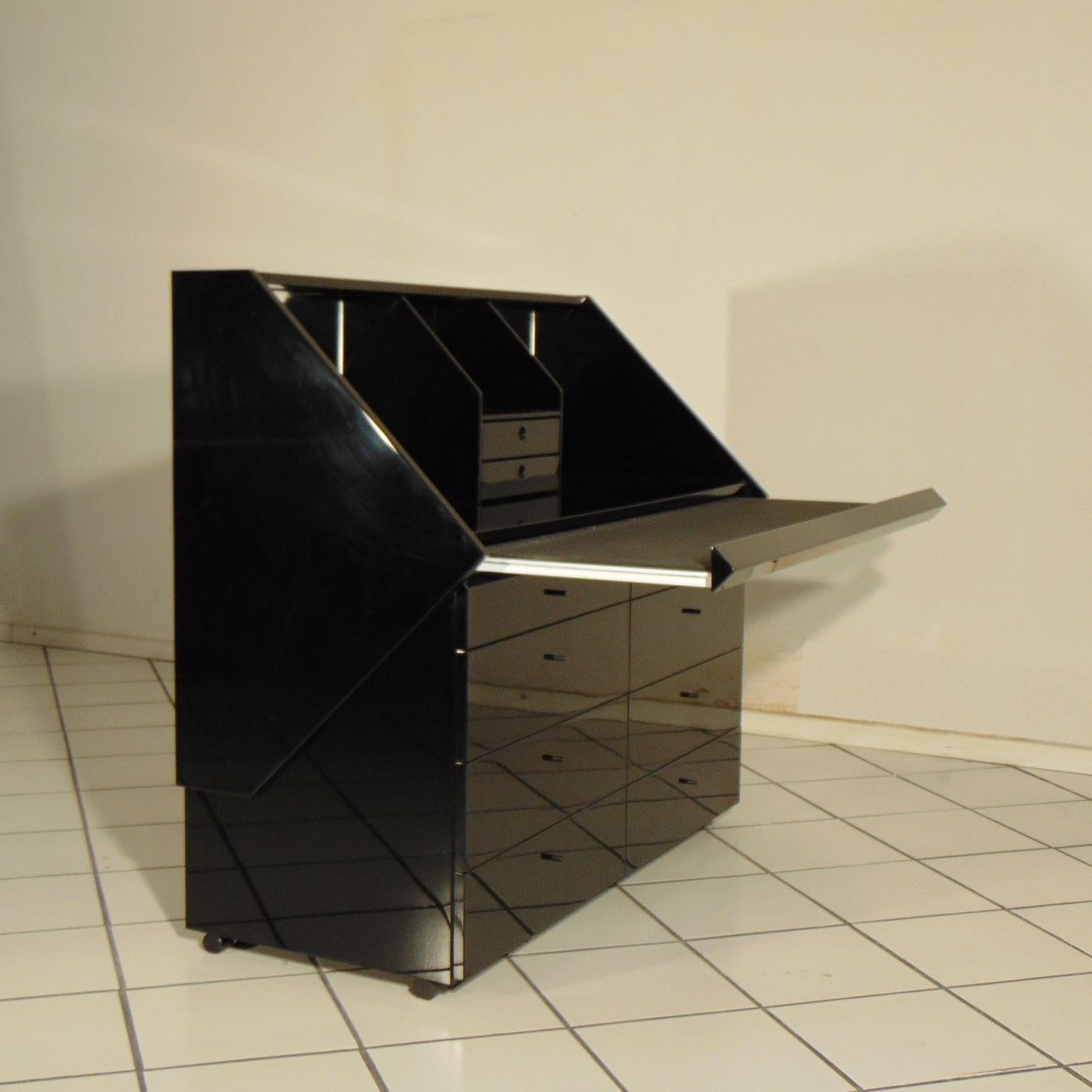 A multifunctional container, this elegant glossy black lacquered piece works:
- As a commode (with six spacious drawers, plus two thinner on the upper side);
- As writing desk, with a pull-out writing top;
- As secretaire with two smaller