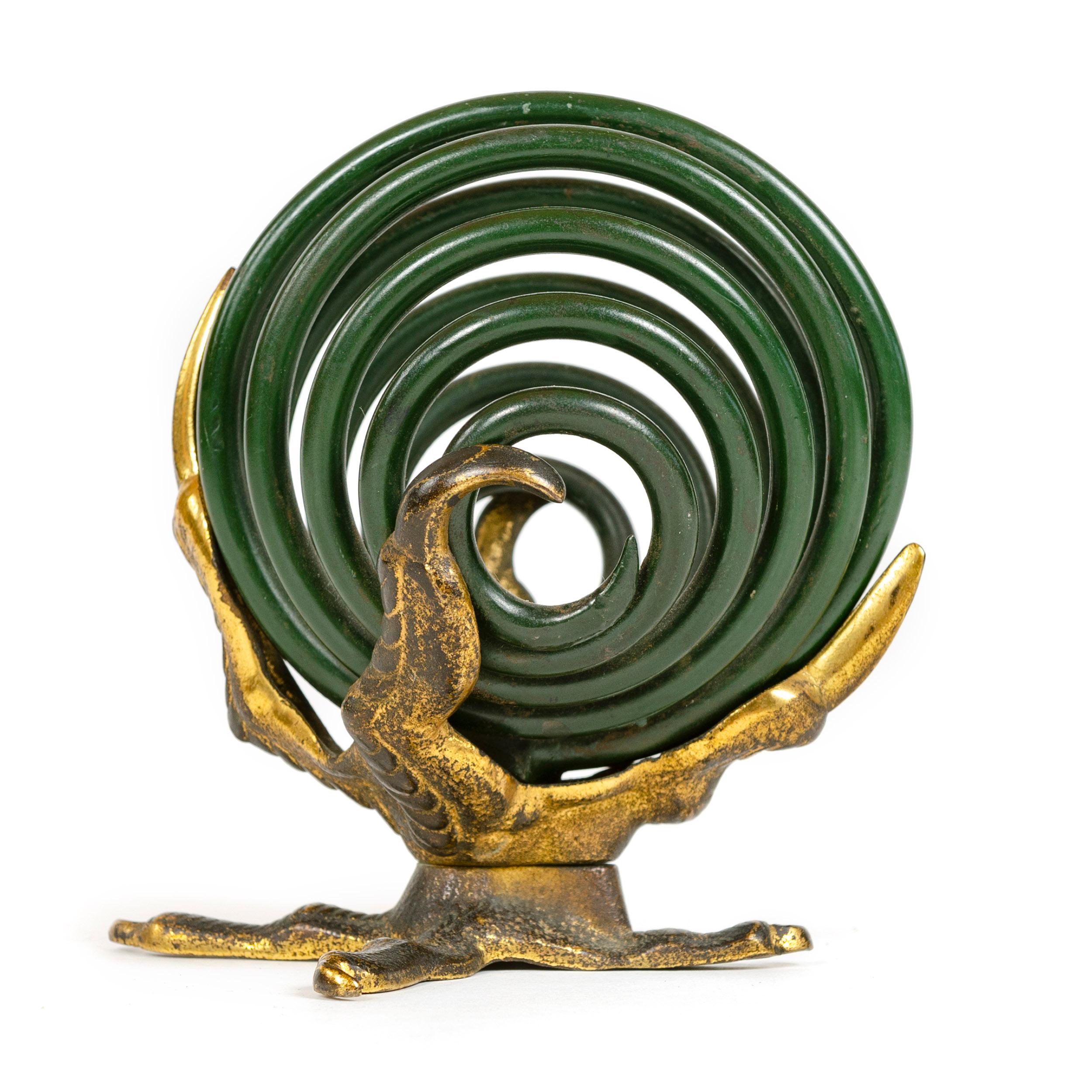 A curious desk accessory useful as a note or letter holder having three bronze talons grasping a coiled, spiral orb made from one continuous strand of thick steel finished in deep green enamel.
  