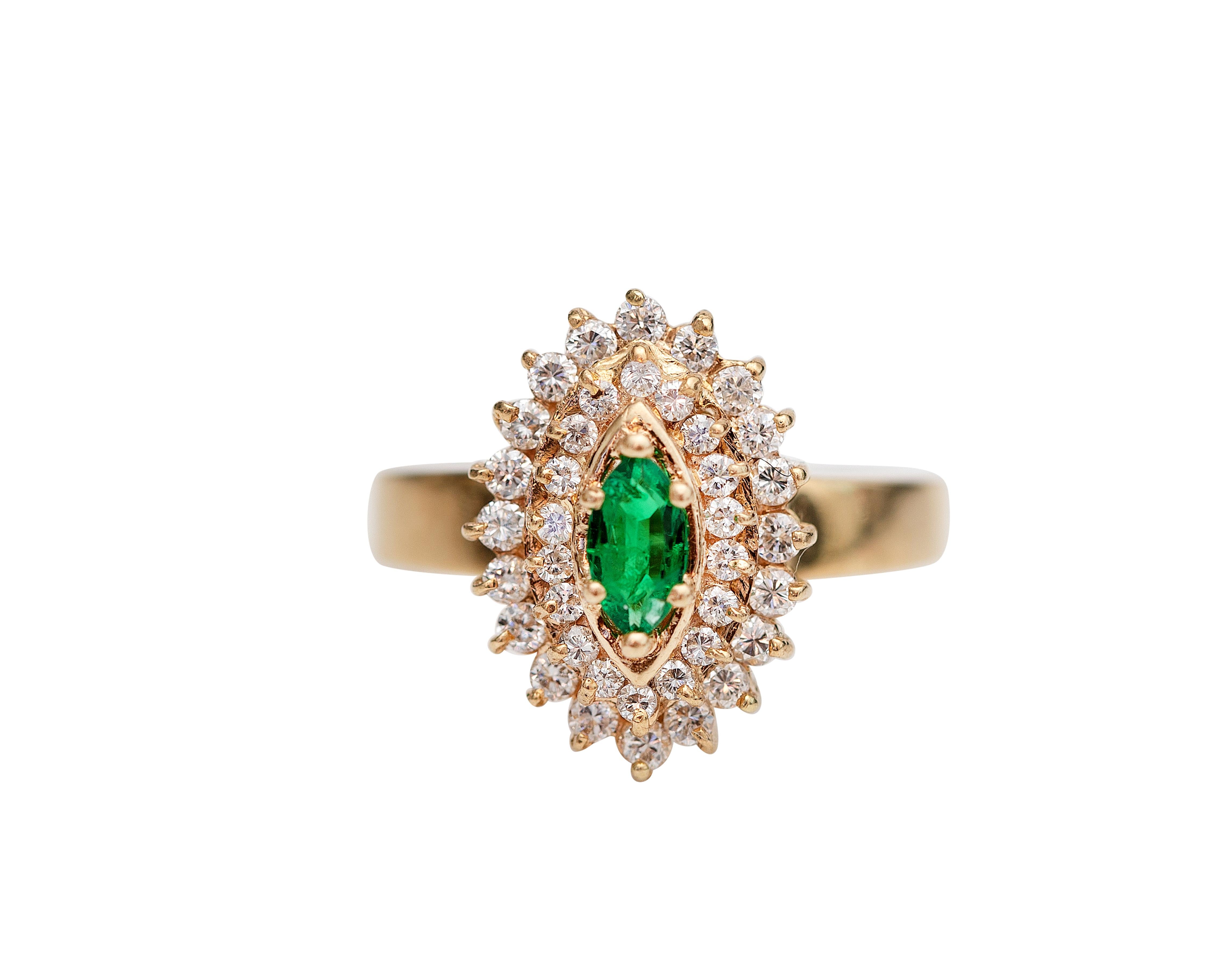 Lovely diamond and emerald ring from the 1980s crafted in beautiful 18 karat yellow gold. The emerald, 6 prong-set, is a beautiful marquise cut, weighing 1.25 carats, and features the most incredible green vibrancy colors. It is surrounded by 3