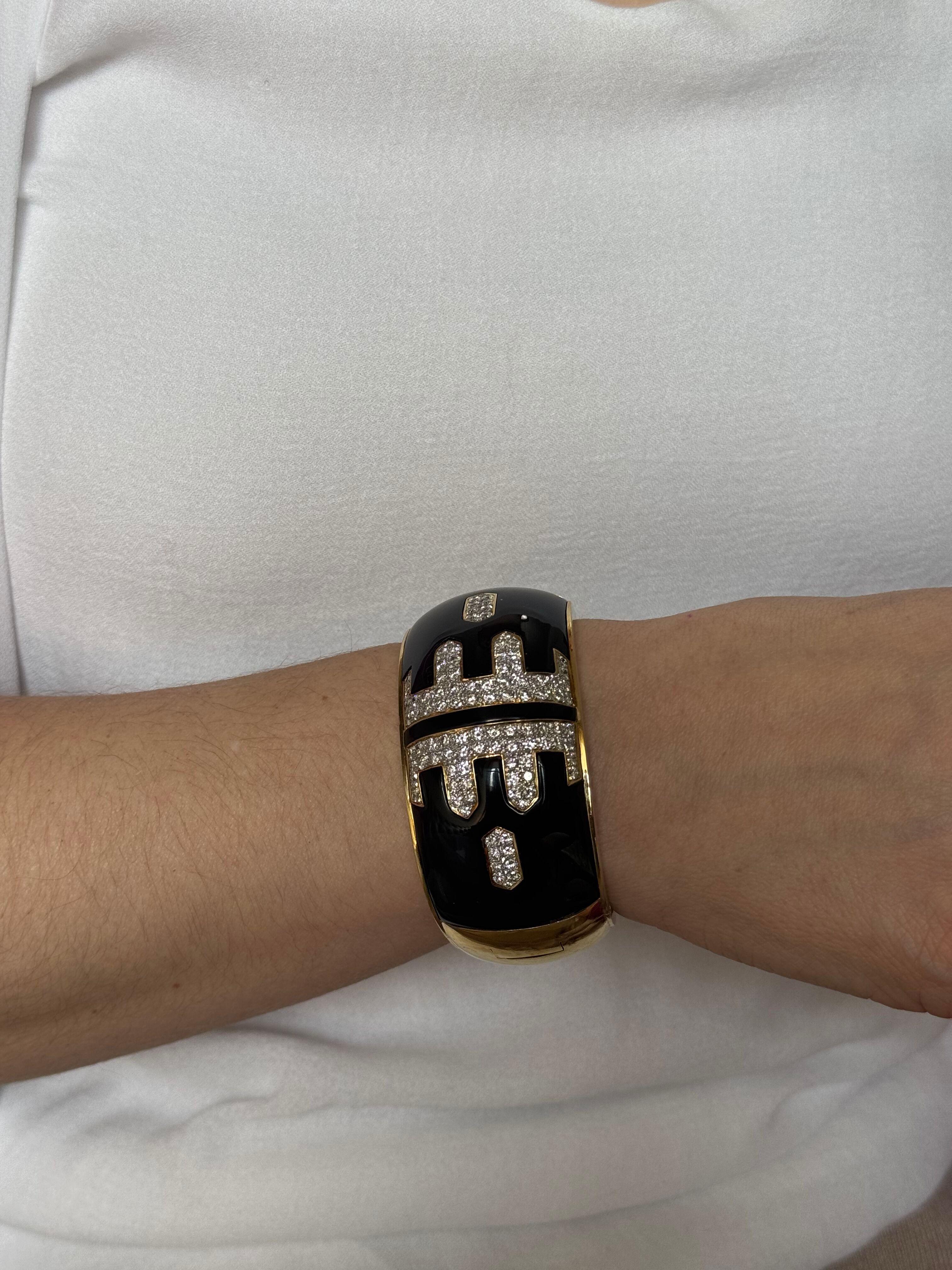 Bracciale bangle classico degli anni '80 in oro giallo 18k, con una cerniera. 
Bracciale con smalto nero laccato e circa 7.00ctw SI1/H.
Il bracciale si adatta a un polso di circa 7 pollici, misura media. Larghezza 1.25