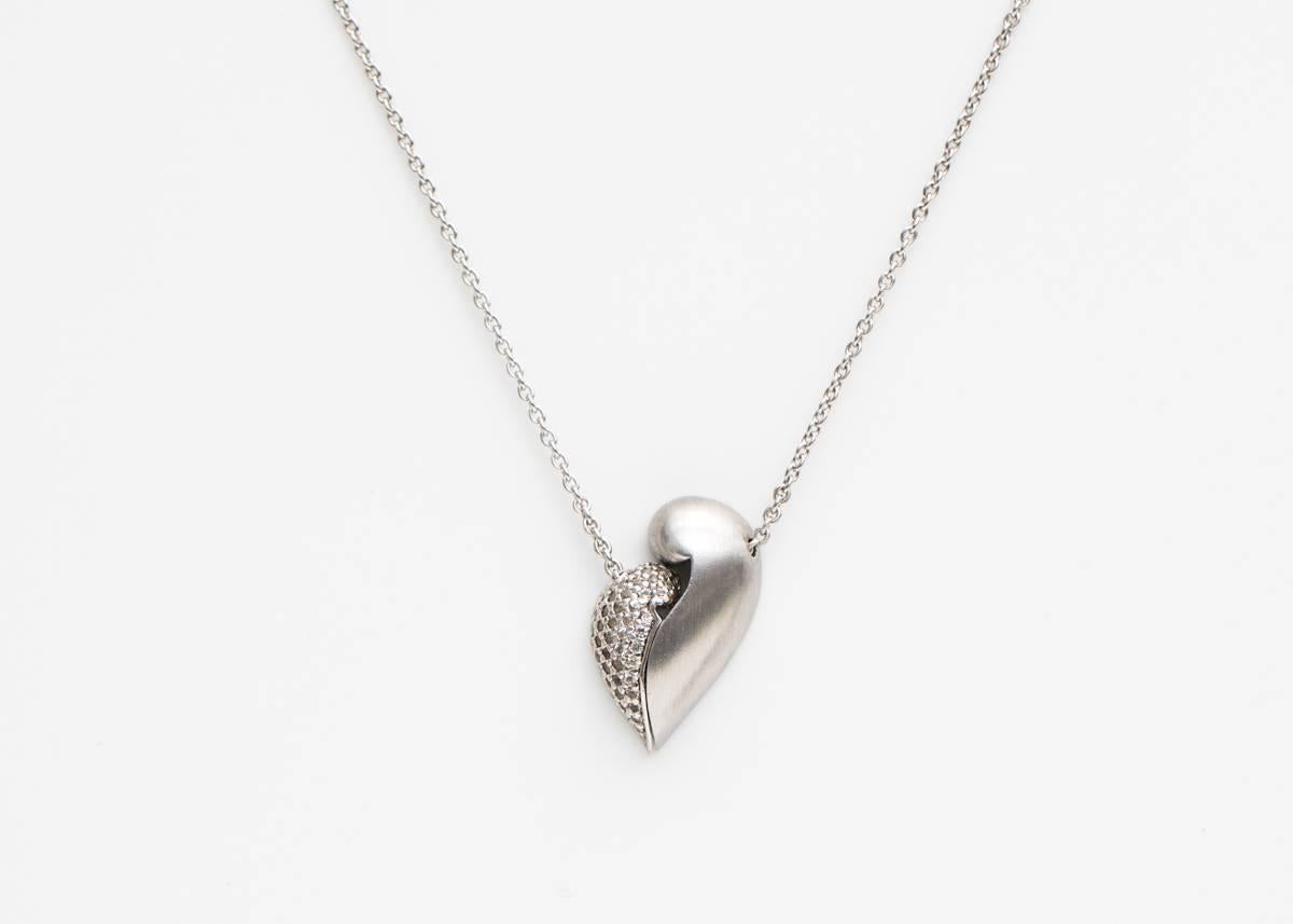 1980s Diamond, Sterling Silver and White Gold Abstract Heart in 2 halves with a Magnetic Connection

Features 'No Greater Love' engraved in fancy lettering on the back of the Diamond half of the Heart. The Heart opens and closes in the center with a