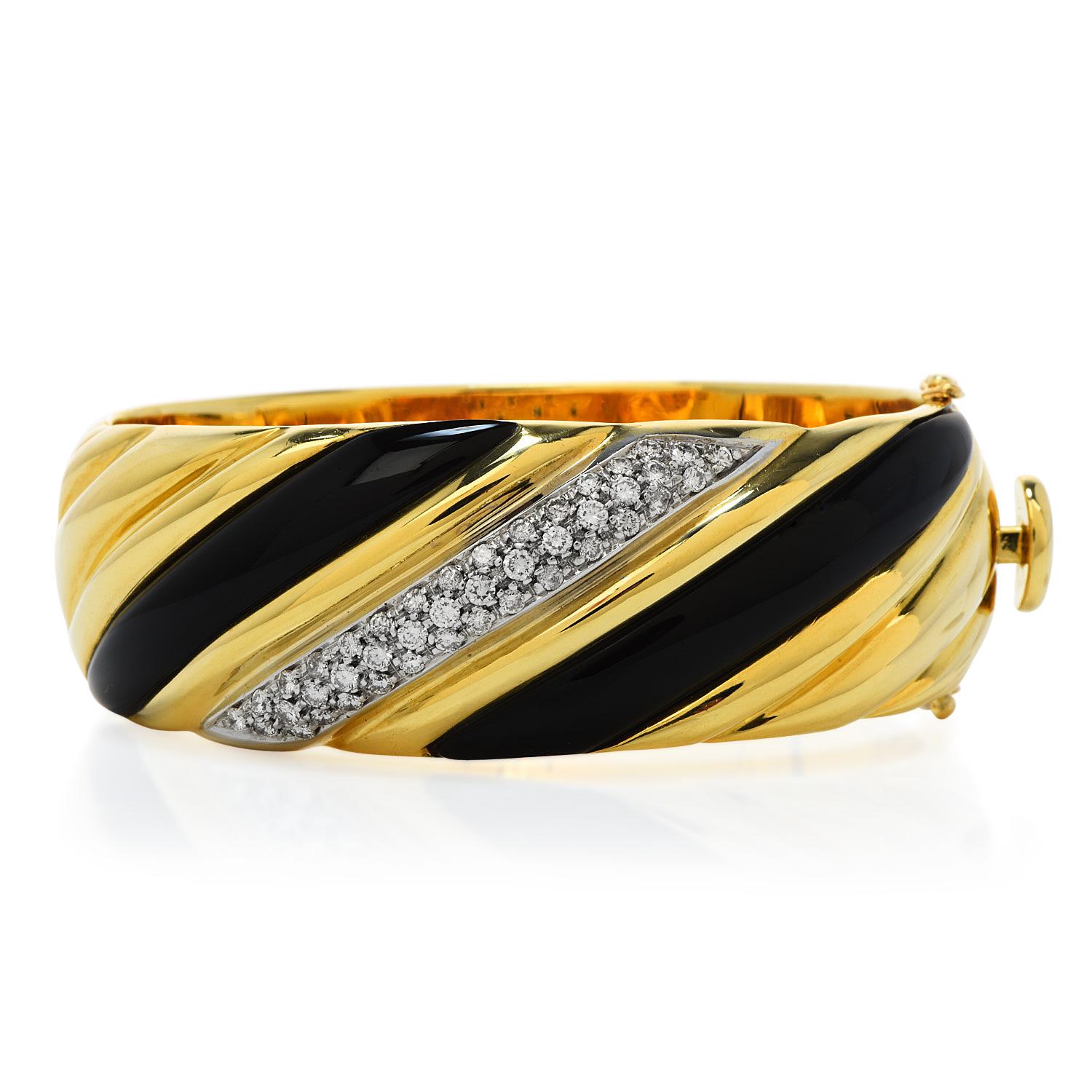 Stand out from the crowd with this statement bracelet.

this 1980S piece is crafted in 18K yellow gold. This exquisite bracelet , has a striped channeled design made of a cluster diamond center & two highly polished black onyx