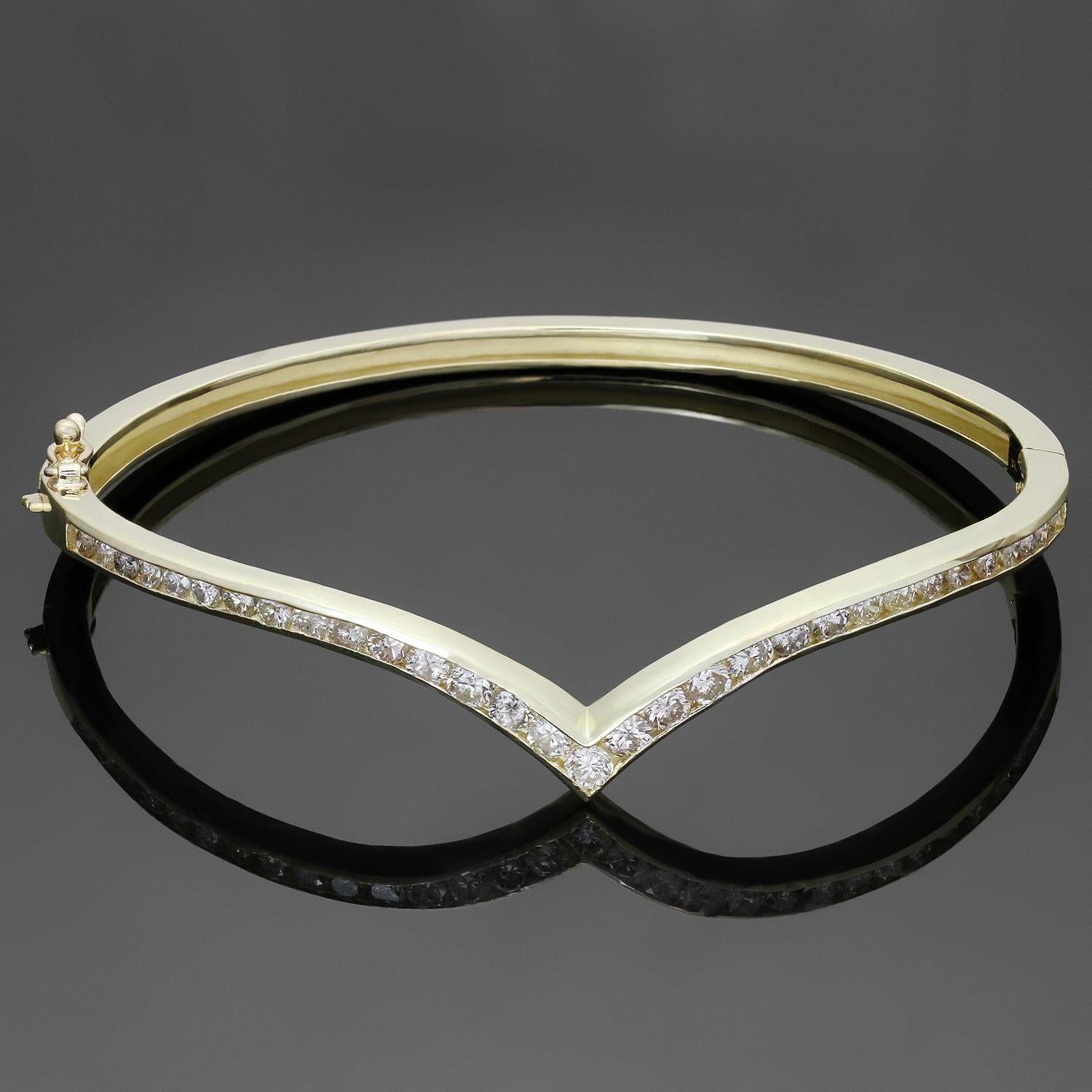 This classic vintage V-shaped bangle bracelet is crafted in 14k yellow gold and set with brilliant-cut round diamonds. Made in United States circa 1980s. Measurements: 0.15