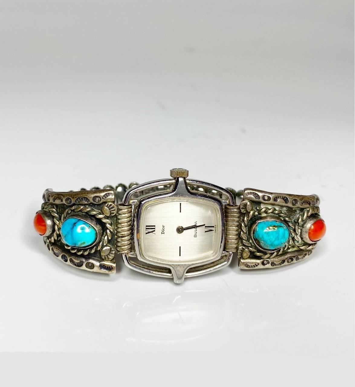 <p>1980s Dior for Bulova Turquoise Coral Silver Mechanical Wristwatch. This timepiece, featuring a stainless flexible western style  strap and a rectangular white dial with elegant Roman numerals, is a true work of art. Adorned with real coral and