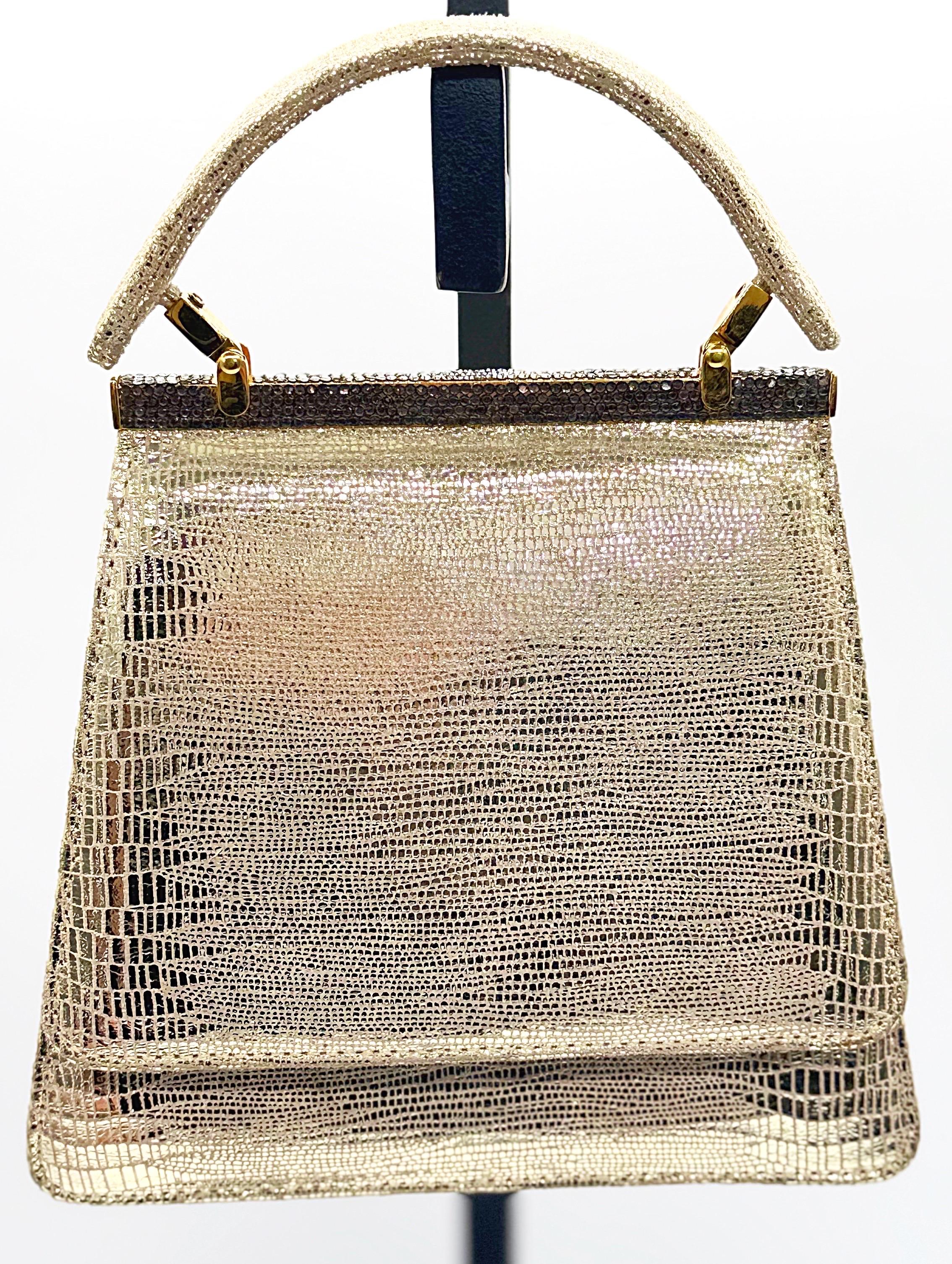 Beautiful Avant Garde 1980s does 1960s gold metallic embossed leather bag ! Features soft embossed leather to look like lizard skin. Top handle, with rhinestones long the bridge. Snap closure.
Can easily be dressed up or down. Pair with a dress,
