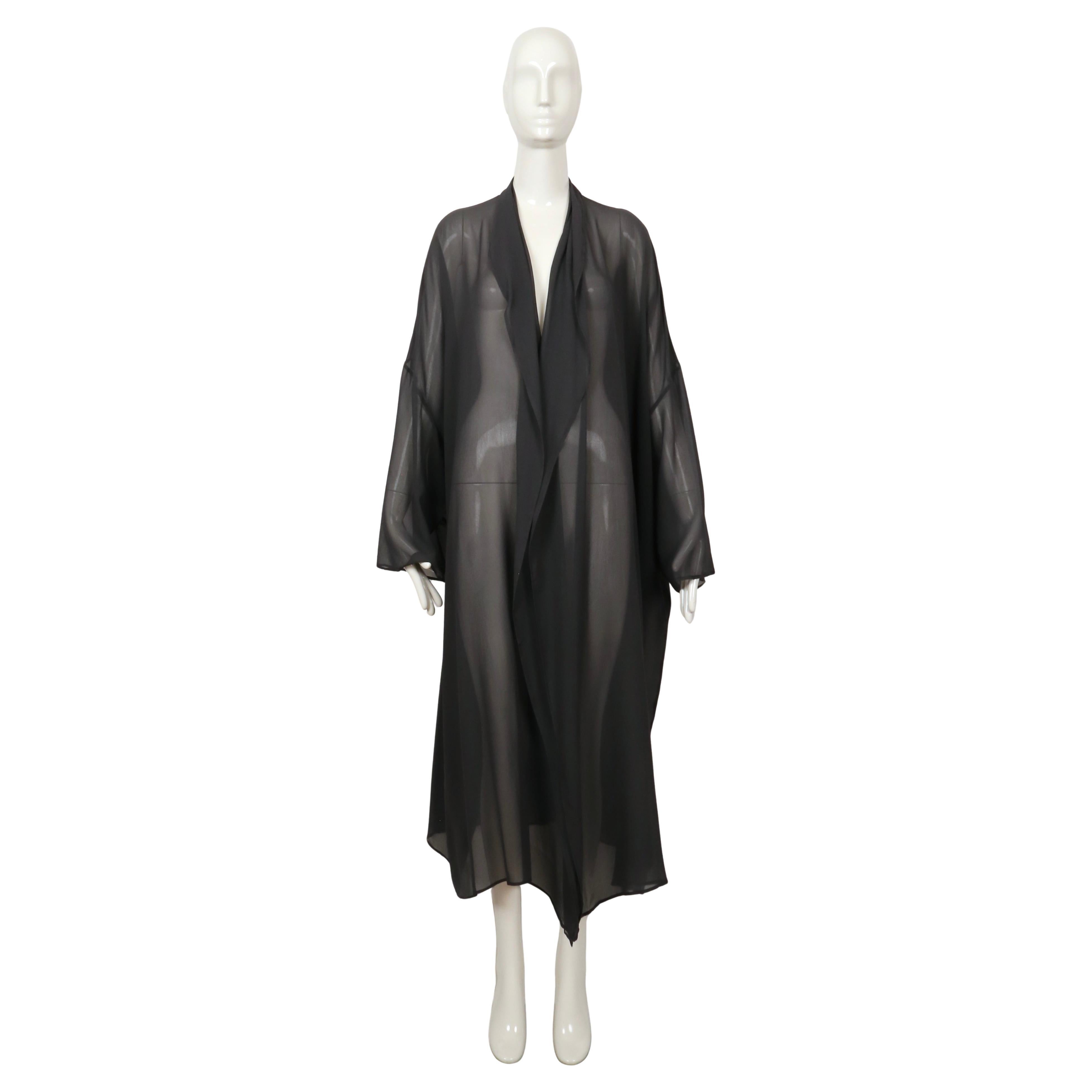Long oversized sheer silk duster coat with open closure from Dolce & Gabbana dating to the late 1980's, possibly early 1990's. Color is a deep dusty green. Duster is labeled an Italian size 40 however it fits very oversized so it can accommodate