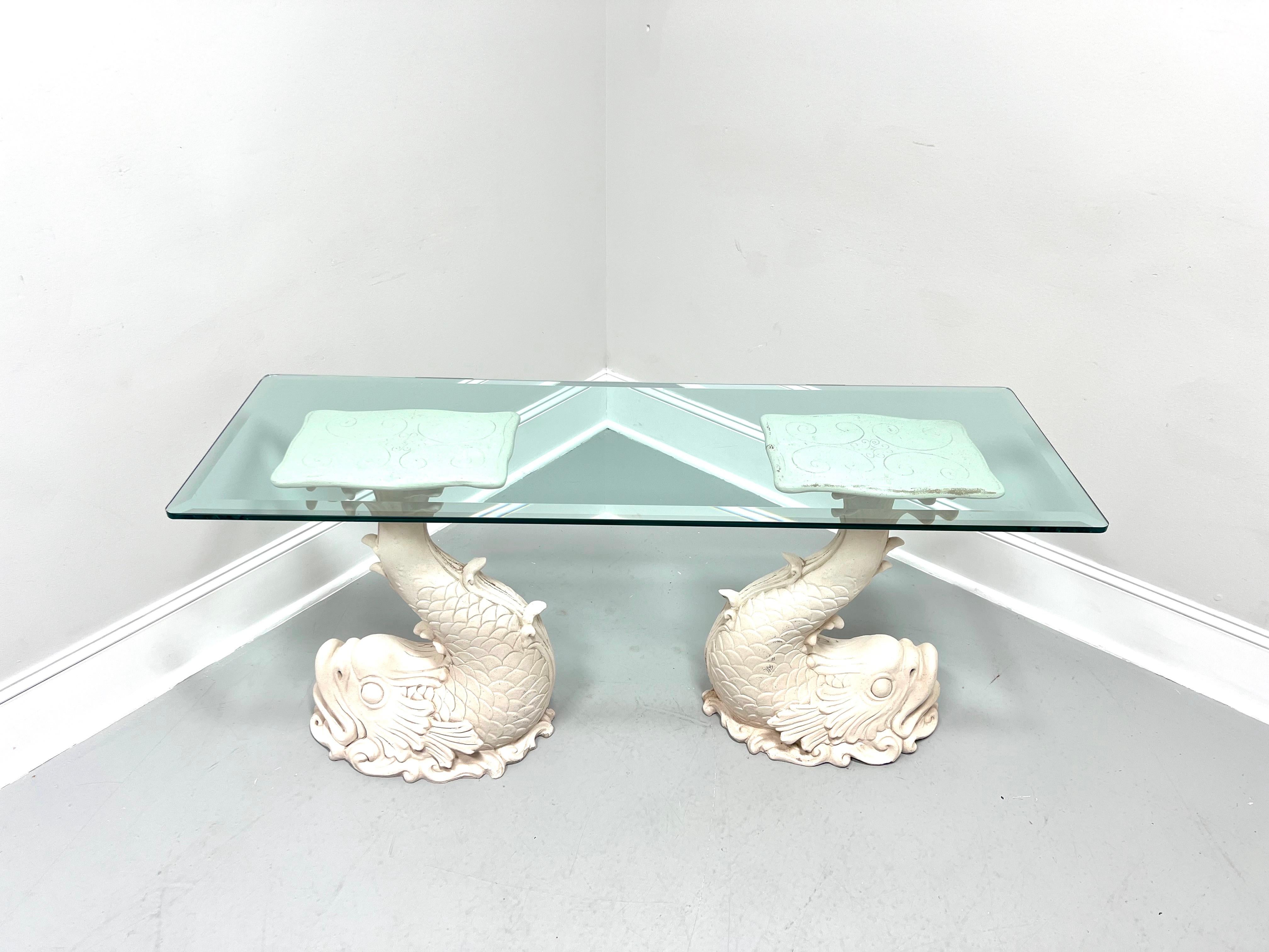 A Coastal / Tropical style glass top console table, unbranded. Two formed resin, or possibly fiberglass, bases painted a beige / off white color in the shape of mythical dolphins with their tails making a flat surface with a decorative design to