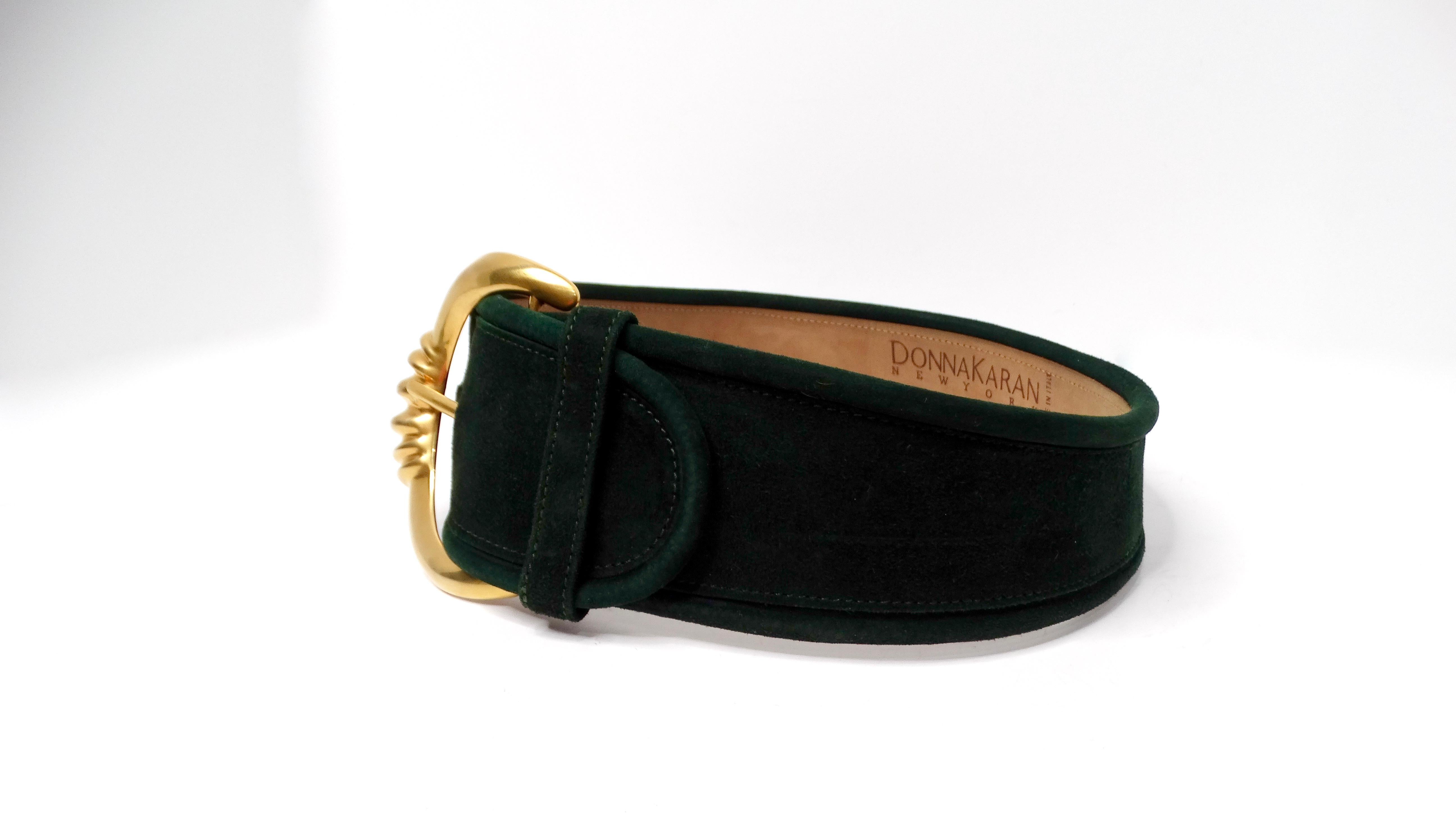 The 1980s Donna Karan Dark Green Suede Leather Chunk Waist Belt is a stunning accessory that captures the essence of vintage luxury. Featuring a large gold-tone buckle, this belt is perfect for making a statement while adding a pop of color to your