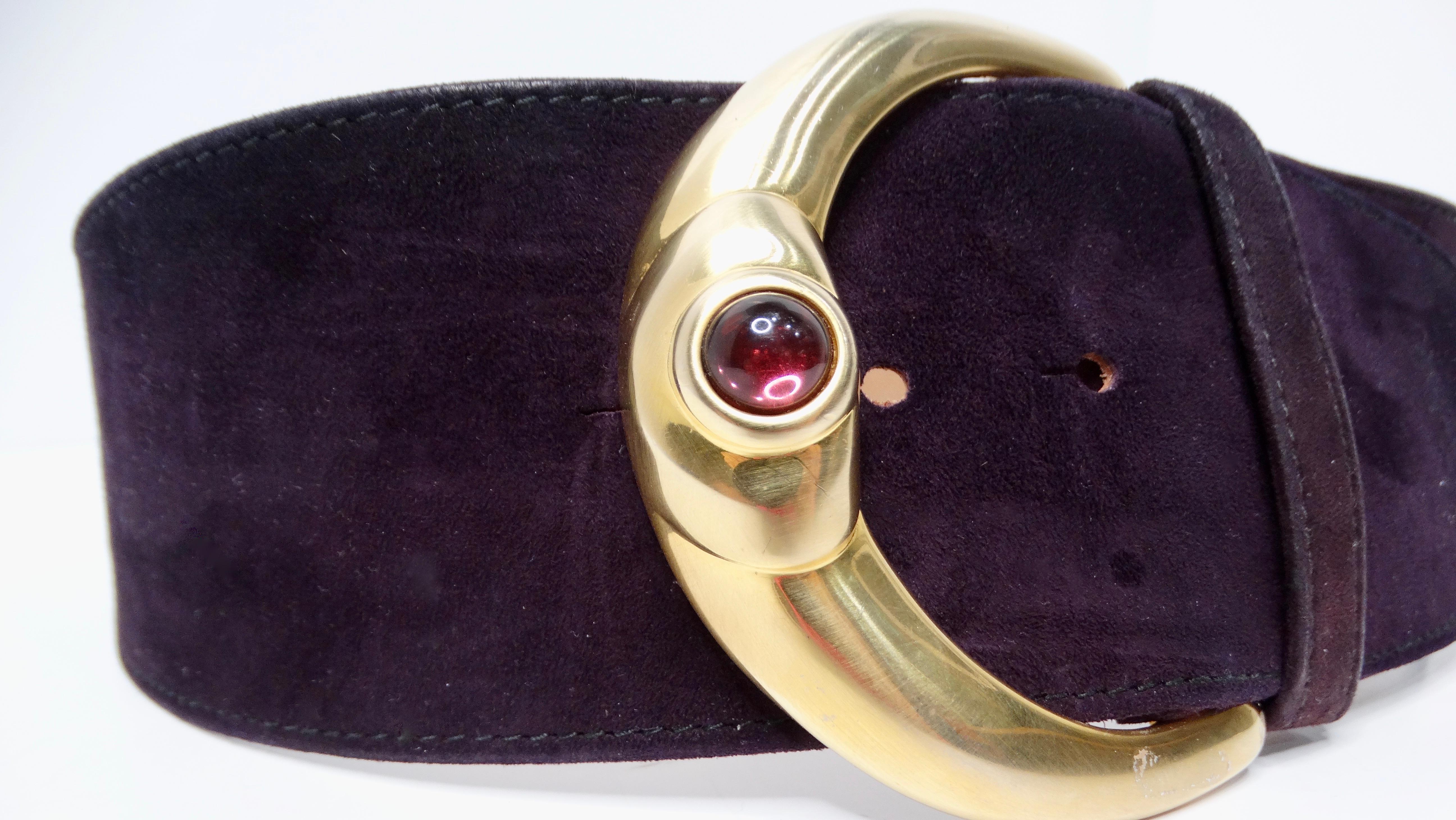 Eleva tu estilo con este impresionante Cinturón de cintura grueso de piel de ante morada de Donna Karan de los años 80. Con una gran hebilla dorada adornada con una llamativa gema de disfraz morada, este cinturón es un accesorio sofisticado que