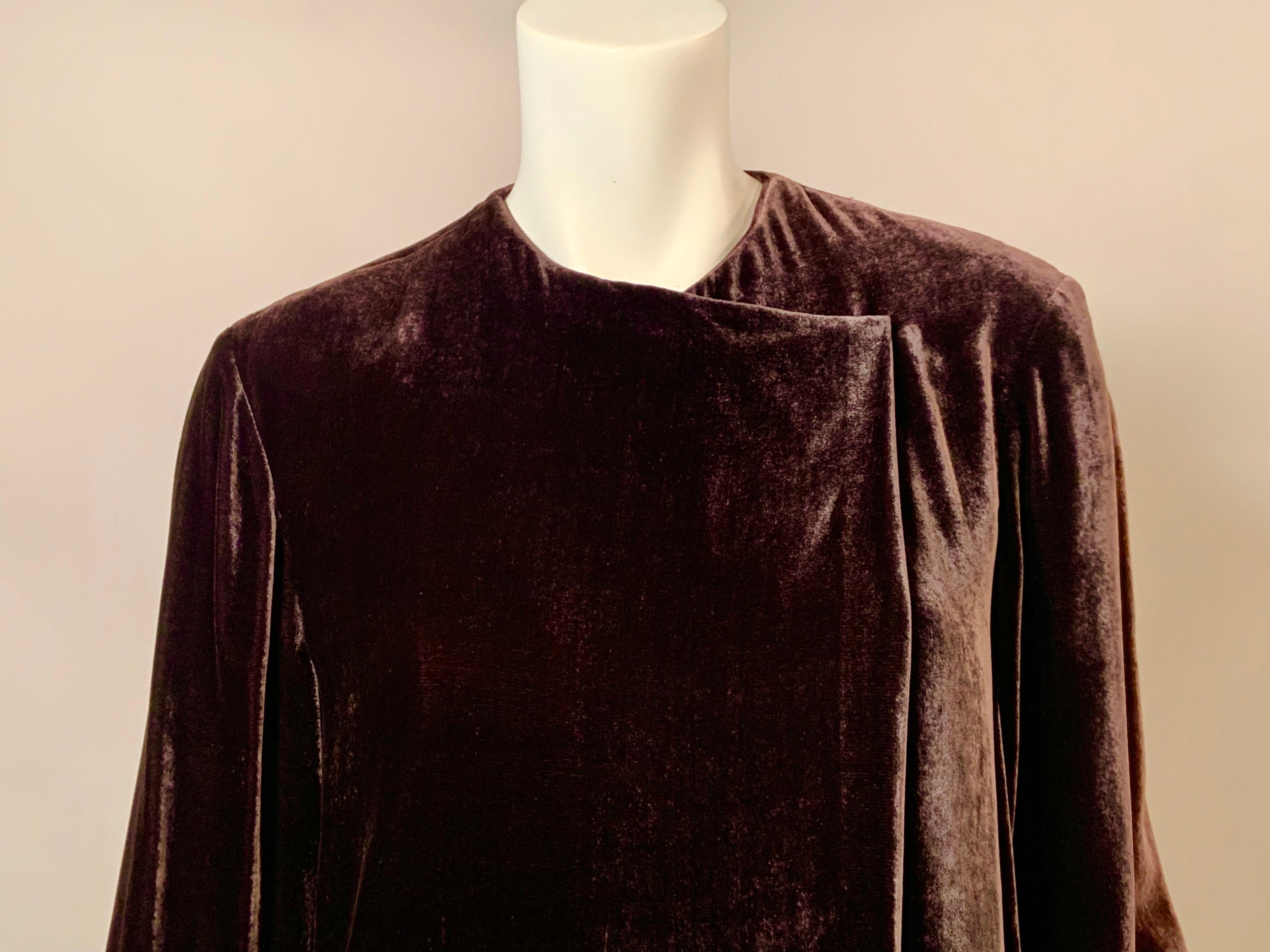 This spare, elegant and lustrous brown velvet coat from Donna Karan can be worn as a coat, a tunic over pants or belted as a dress.  It has two hooks for closure, as well as the optional belt.  It has two pockets hidden in the side seams, and it is