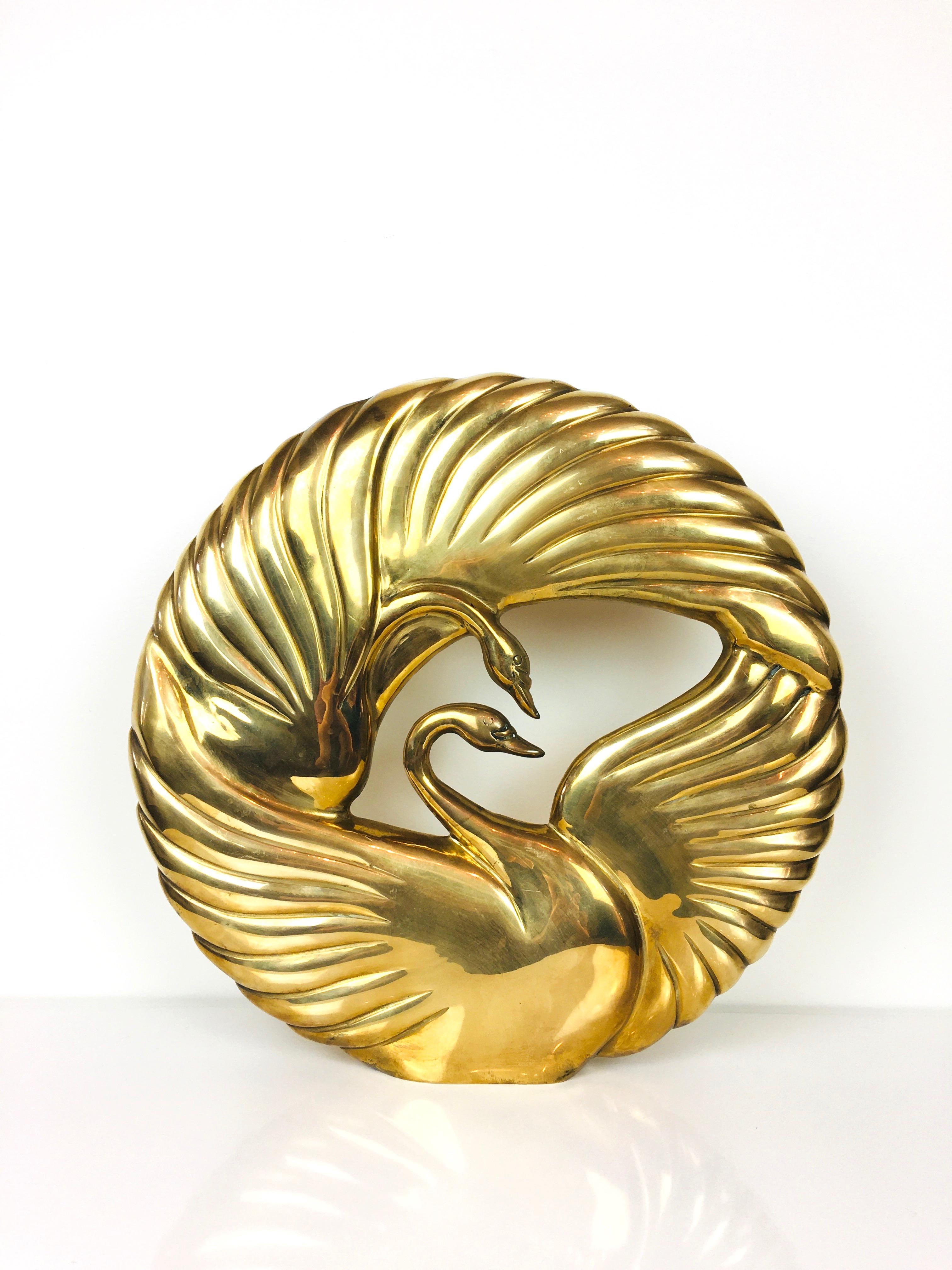 Striking 1980s brass Art Deco style double swan table sculpture by Dolbi Cashier.
Round shape & double sided. 
Nice warm glow, polished. 
Labels at base. 
Very good condition, light surface wear.