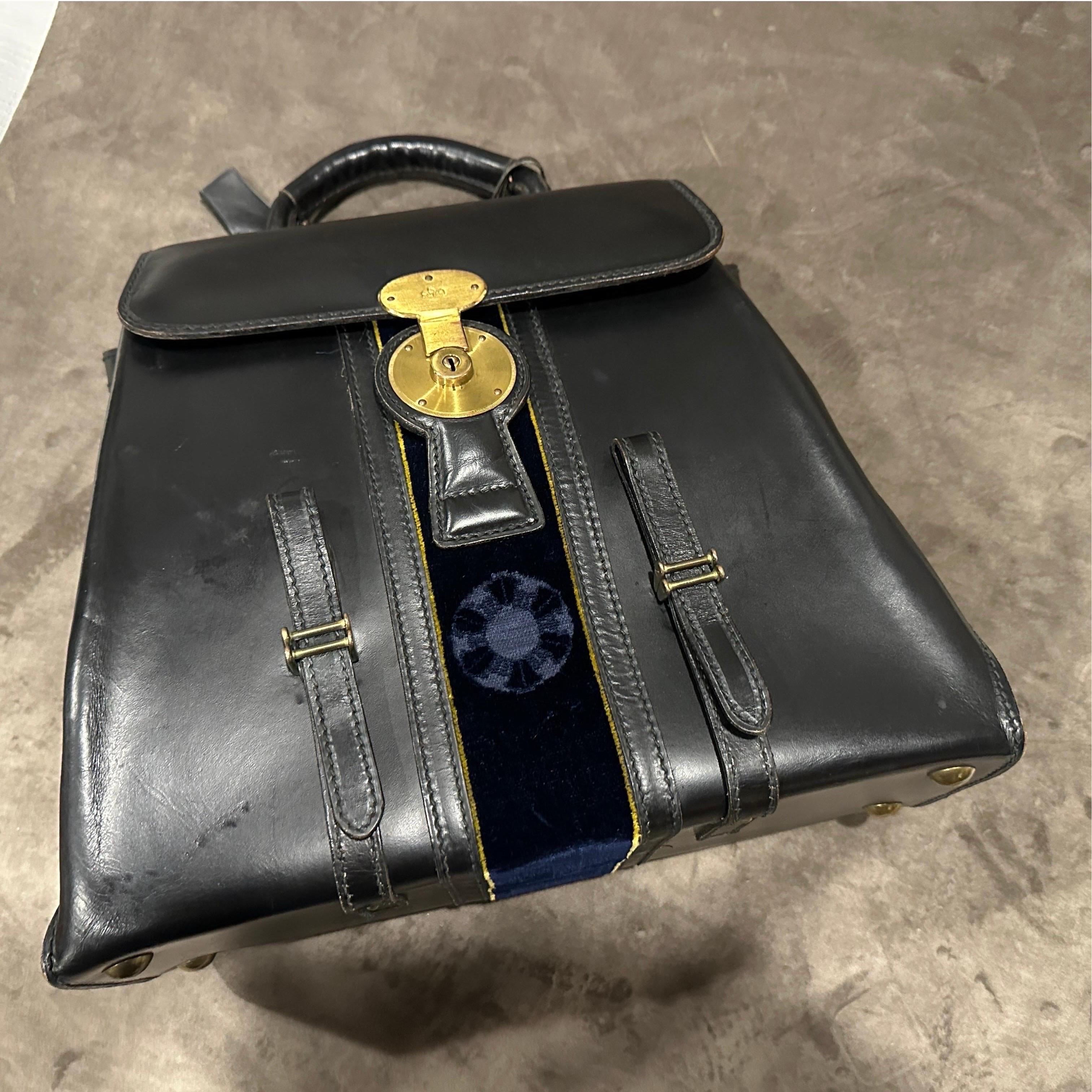 Questa sofisticata borsa è un bellissimo esempio di design italiano degli anni '80 del rinomato marchio di lusso Roberta Di Camerino. Realizzata con una combinazione di pelle nera liscia e un sorprendente pannello centrale di velluto blu profondo,