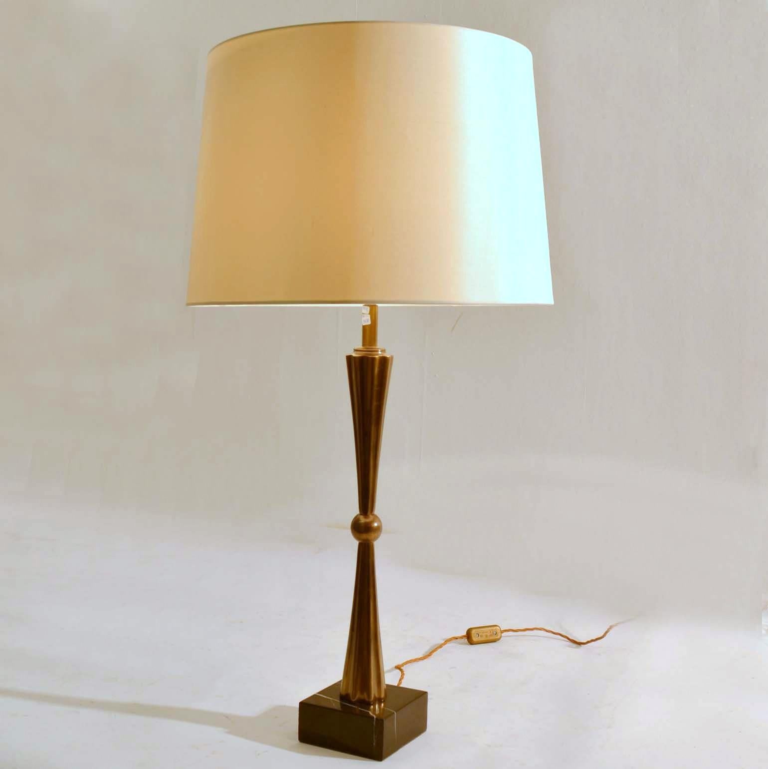 Tall and slender table lamps in bronze patinated brass standing on black marble bases with white veins holding new ivory white shades. 

Dimensions bases: 12 x 12 x H 60 cm.