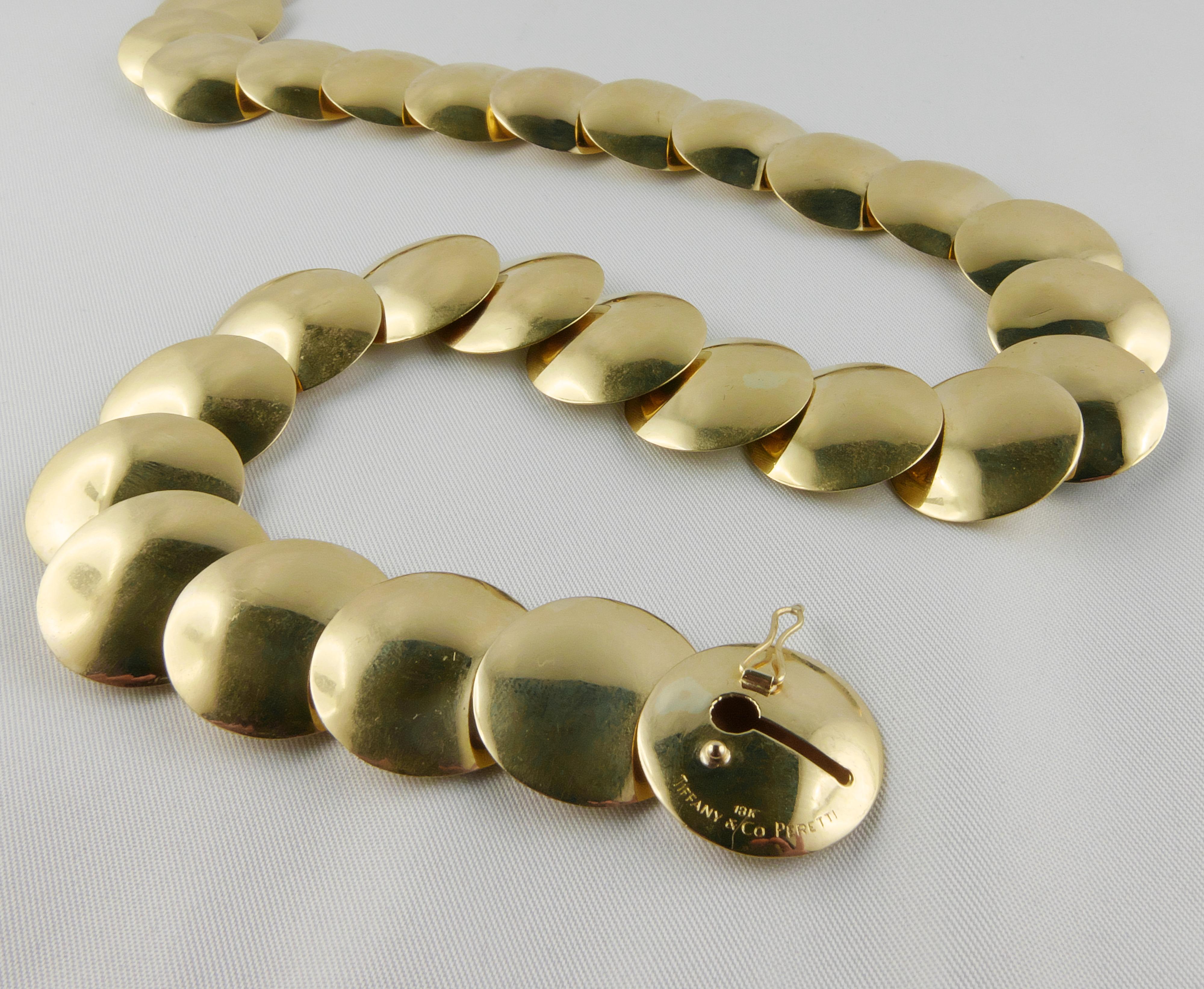 1980s luminous flexible Necklace signed Elsa Peretti TIFFANY & CO. Crafted in polished 18k  Yellow Gold, is made of 29 round bombé discs. 
Stylish and very chic, this Necklace is enlighted with a pavé of  round  cut sparkly Diamonds on one of the
